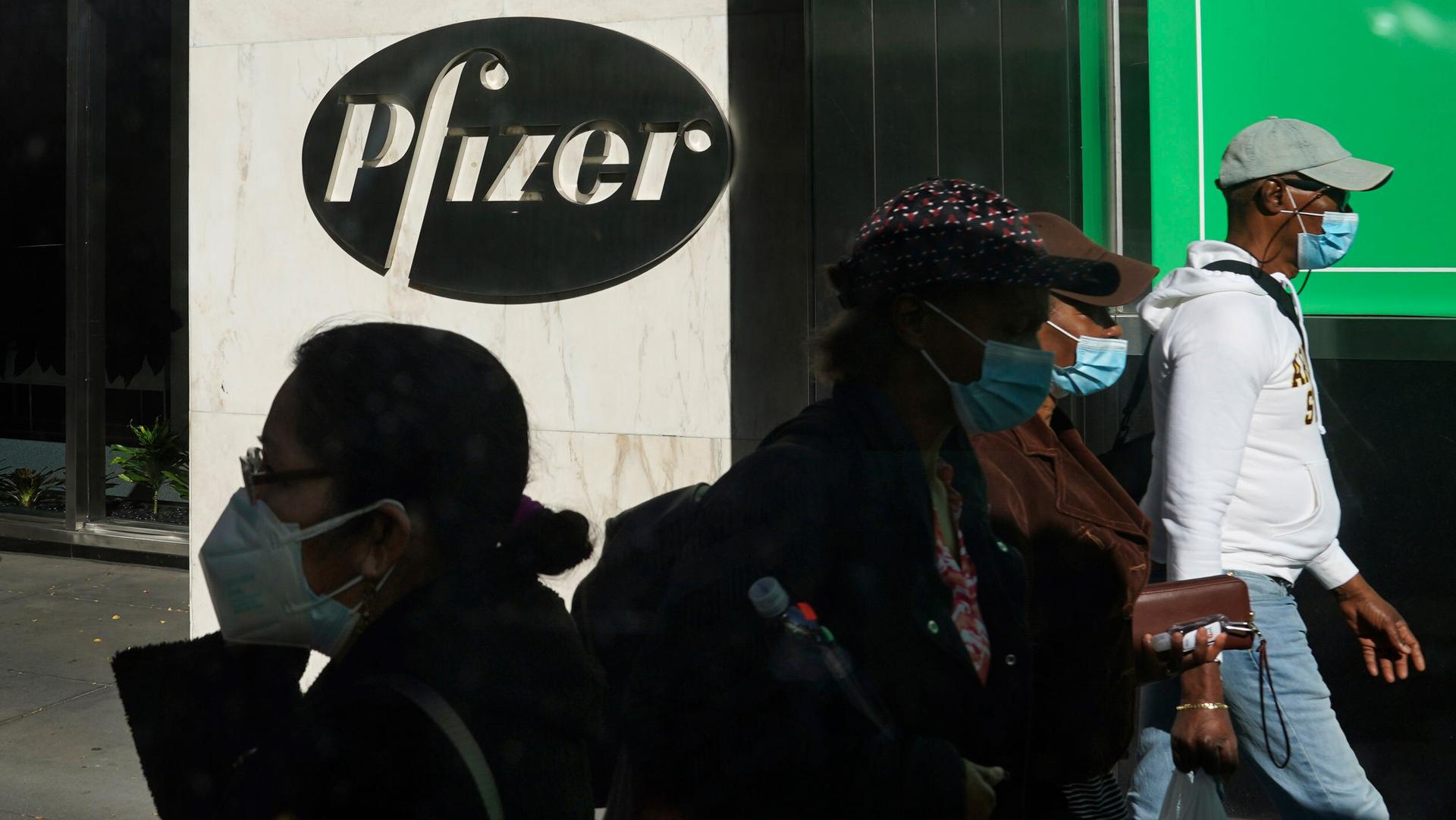 People walk past Pfizer world headquarters in New York City, Nov. 9, 2020.