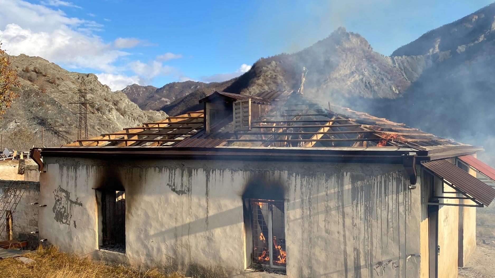 A house set on fire by departing Armenians in the region of Kelbajar