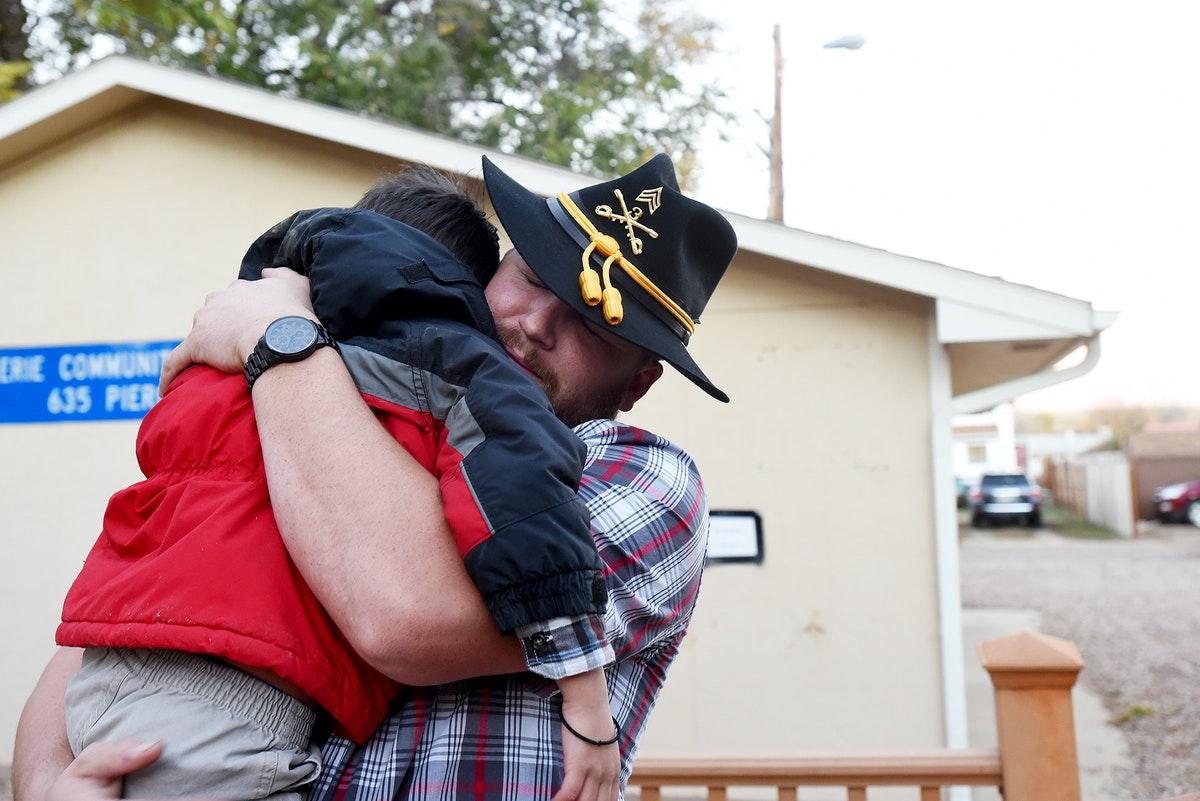 A veteran is hugged by his son
