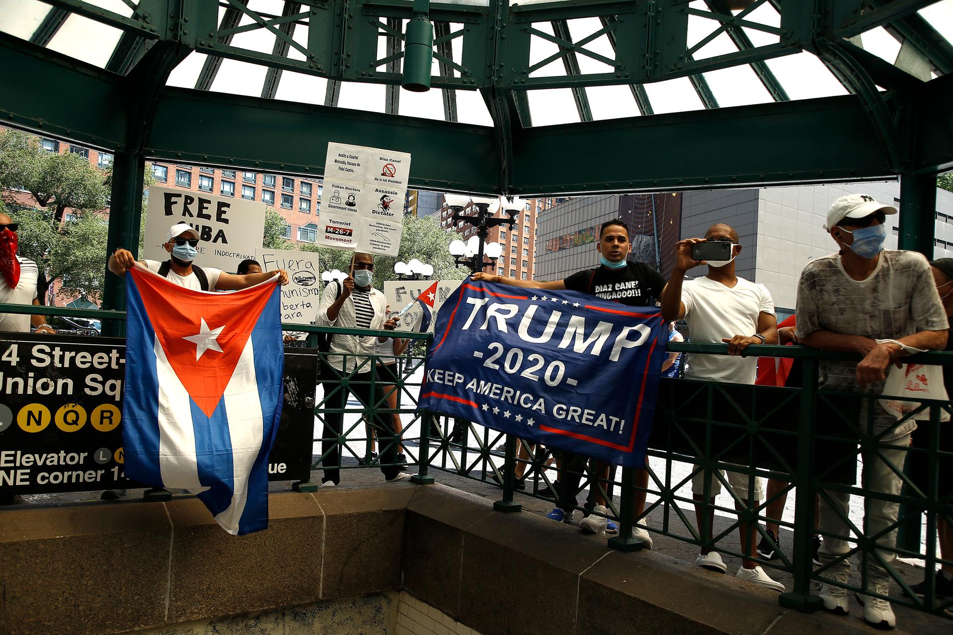 A row of Cuban Americans holding up pro-Trump flags.