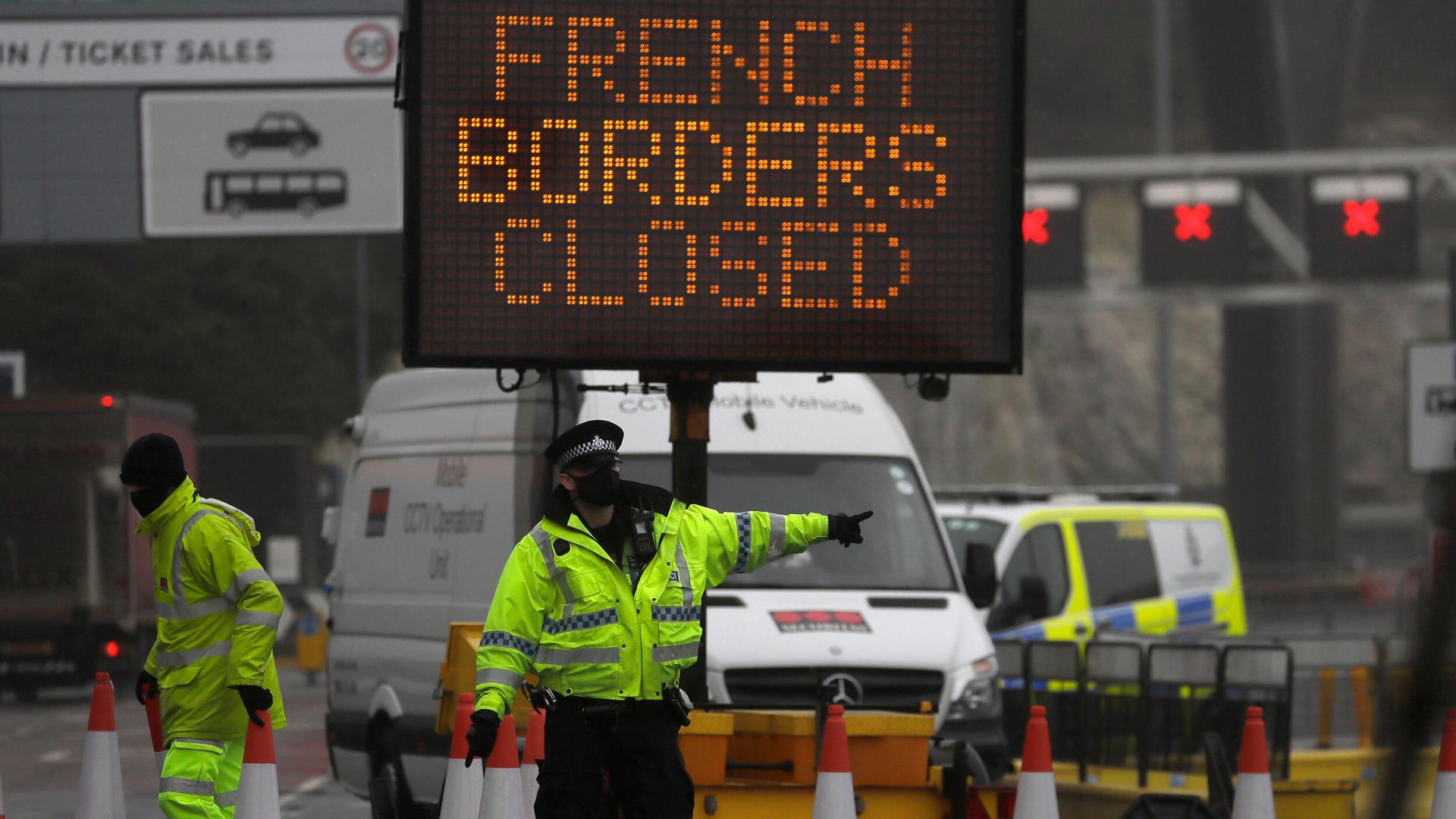 A police officer directs traffic at the entrance to the closed ferry terminal in Dover, England, after the Port of Dover was closed and access to the Eurotunnel terminal suspended following a French government's announcement.