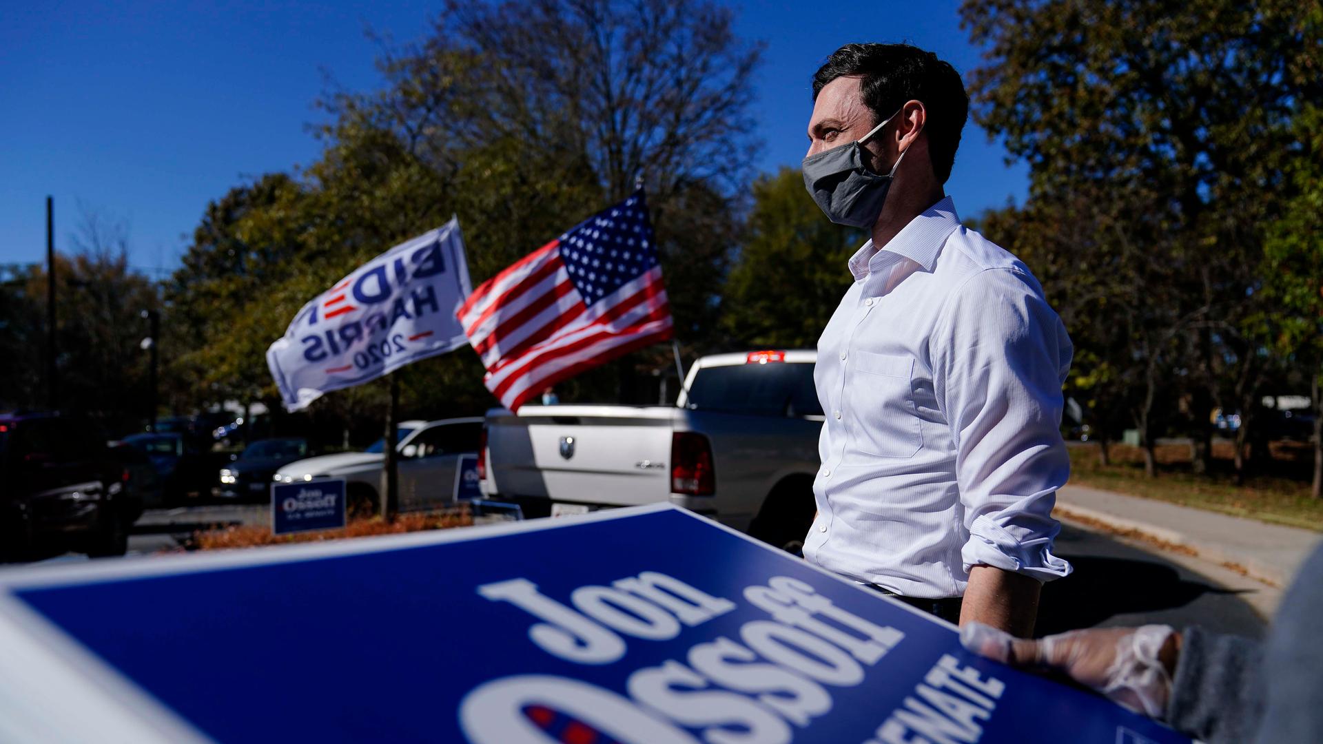 Georgia Democratic candidate for US Senate Jon Ossoff waits for a supporter to arrive during a drive-through yard sign pick-up event on Nov. 18, 2020, in Marietta, Georgia.