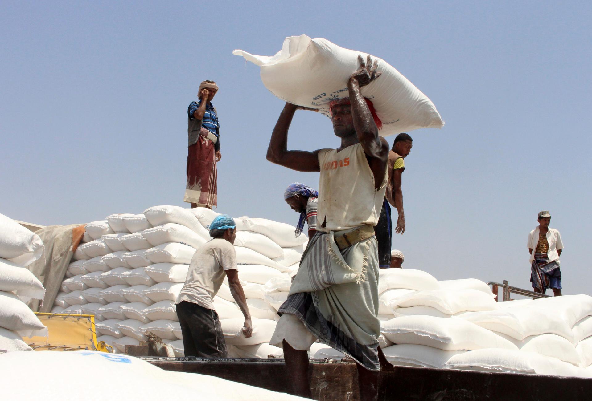 In this file photo, men deliver UN World Food Program (WFP) aid in Aslam, Hajjah, Yemen, Sept. 21, 2018.