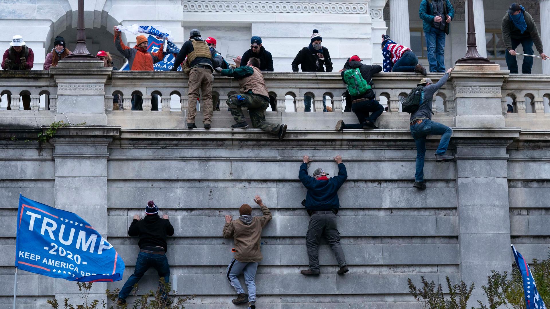 Supporters of President Donald Trump climb the West wall of the the US Capitol on Wednesday, Jan. 6, 2021, in Washington, DC.