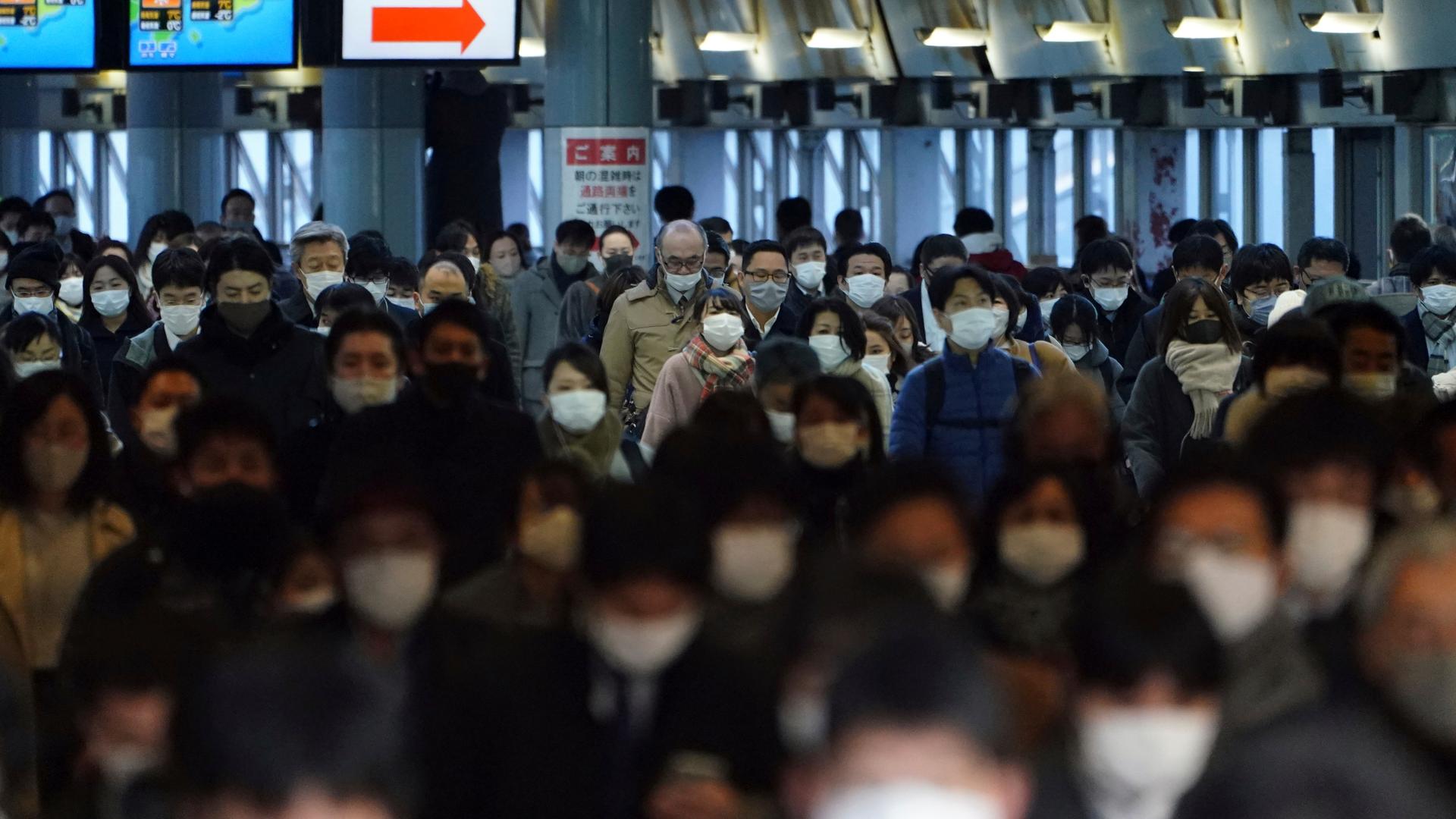 A station passageway is crowded with commuters wearing face mask during a rush hour Friday, Jan. 8, 2021, in Tokyo. 