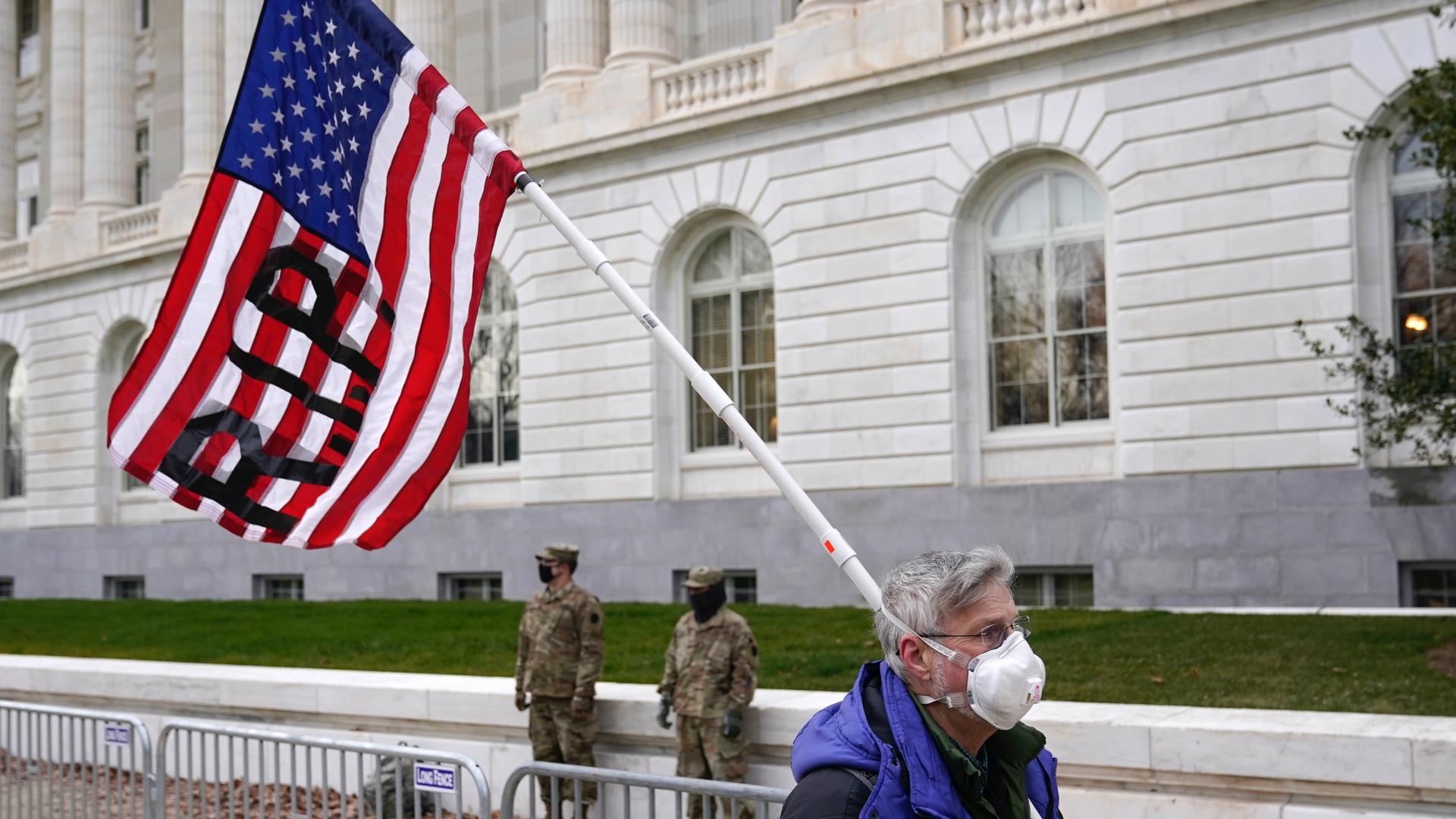 A protester walks past the Russell Senate Office Building on Capitol Hill in Washington, Friday, Jan. 8, 2021.
