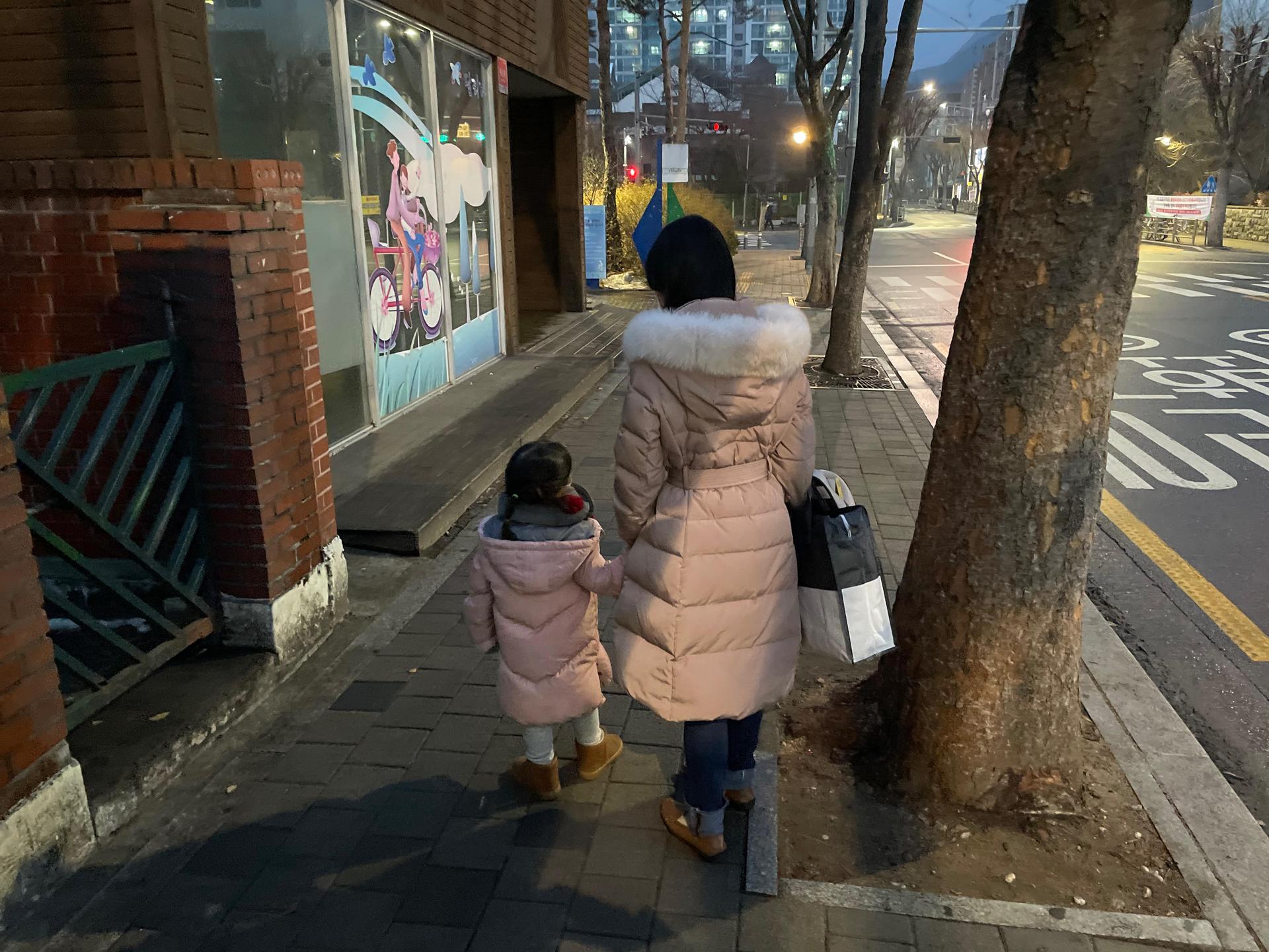 Kim, an advocate at the Korean Unwed Mothers Families' Association, a support group in Seoul, South Korea, walks with her daughter. She asked that her full name not be used due to the stigma associated with being a single mother.