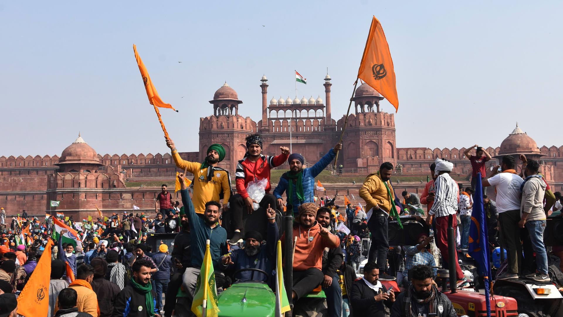 Sikhs wave the Nishan Sahib, a Sikh religious flag, as they arrive at the historic Red Fort monument in New Delhi, India, on Tuesday, Jan. 26, 2021.  