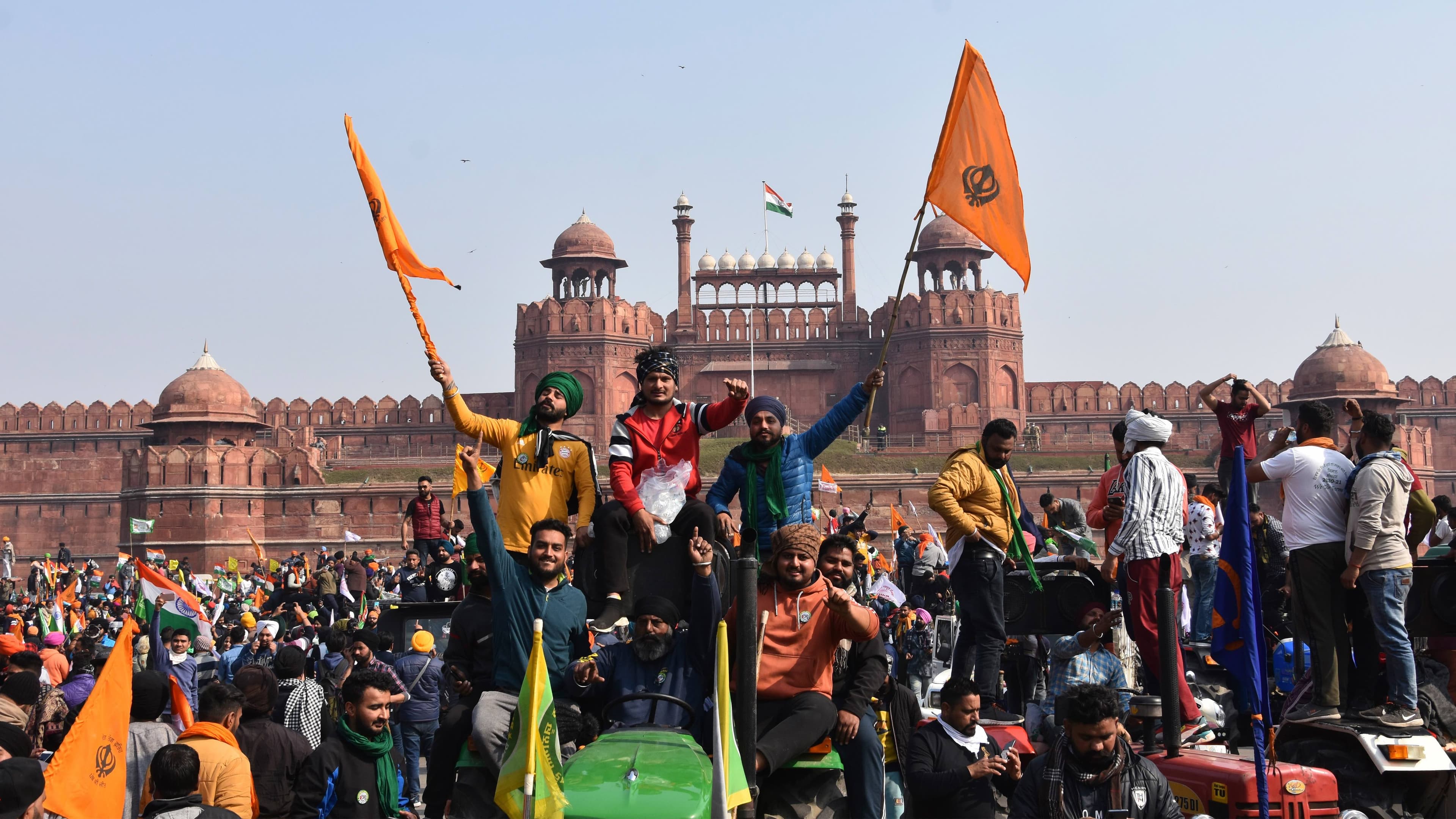 Sikhs wave the Nishan Sahib, a Sikh religious flag, as they arrive at the historic Red Fort monument in New Delhi, India, on Tuesday, Jan. 26, 2021.