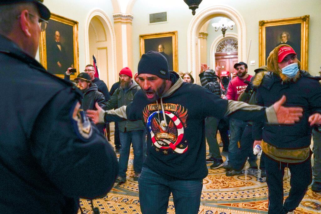Trump supporters gesture to US Capitol Police in the hallway outside of the Senate chamber at the Capitol in Washington, Jan. 6, 2021.