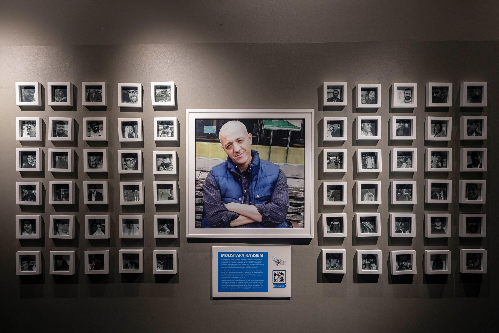 A memorial shows a photo of a man surrounded by several other frames in a gallery.