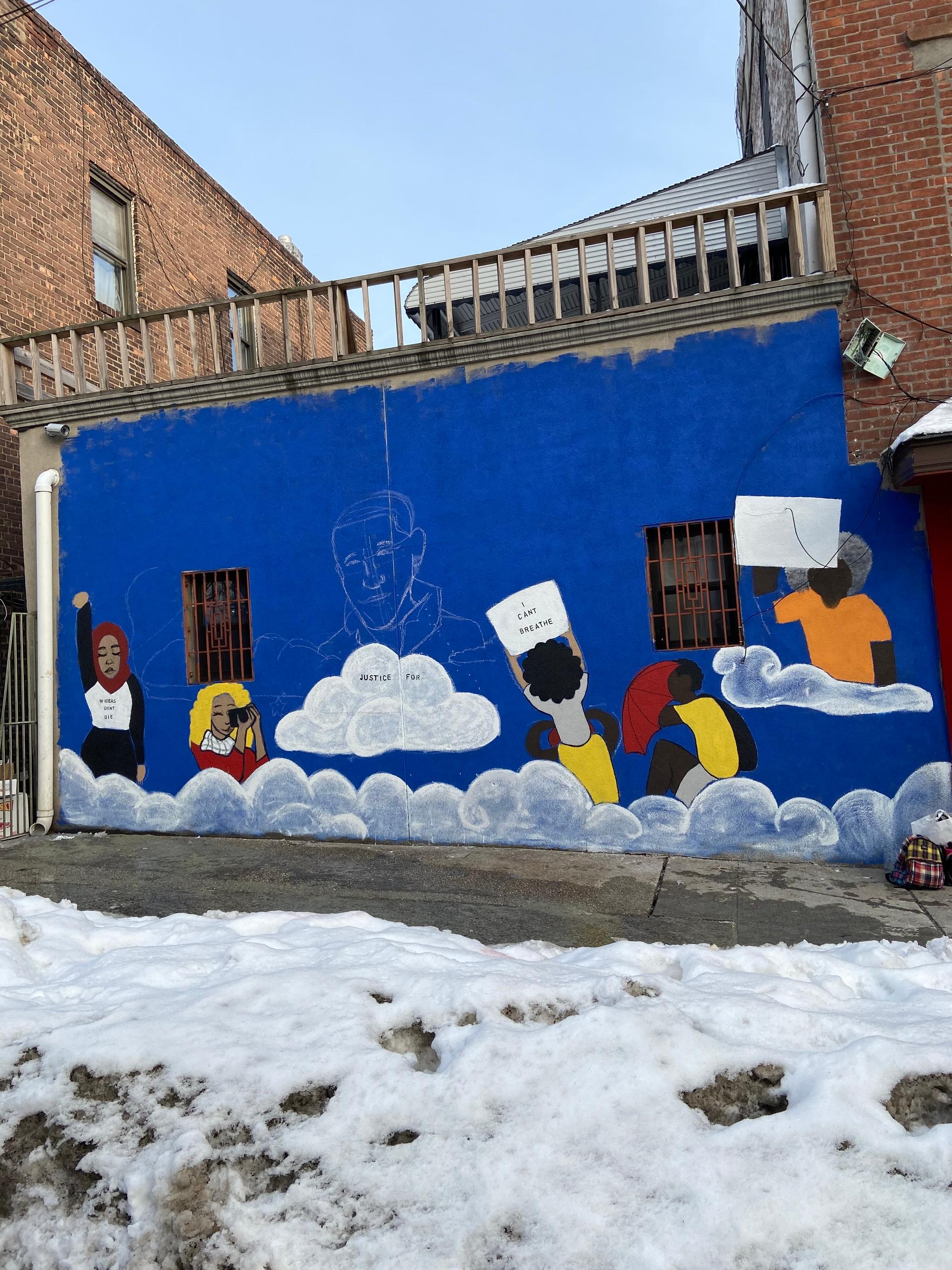 A photo of an unfinished mural in a snowy lot.
