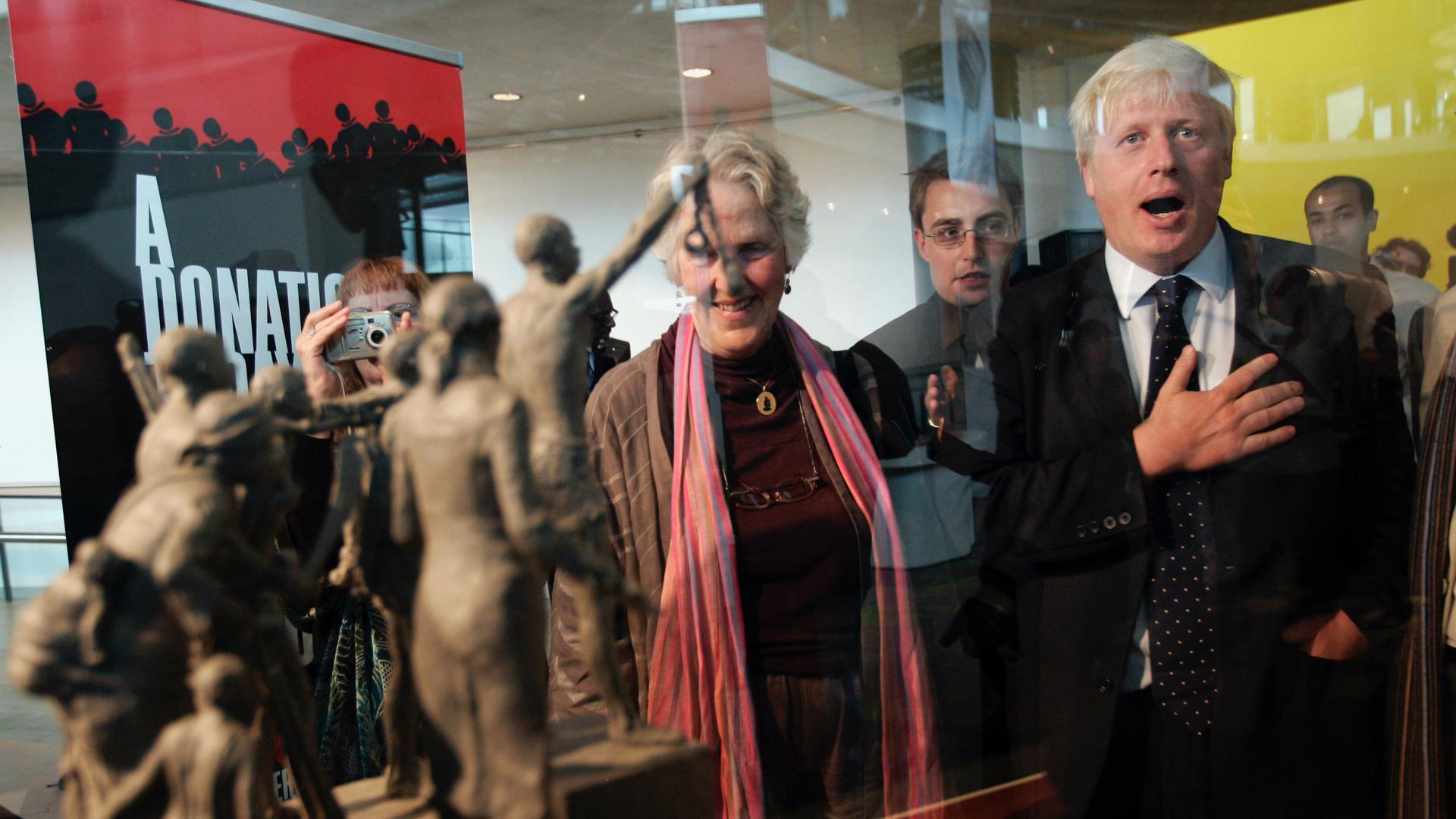 Former mayor of London Boris Johnson, right, is seen by a maquette of a statue that stands as a permanent slavery memorial statue at City Hall in London, Aug. 18, 2008.