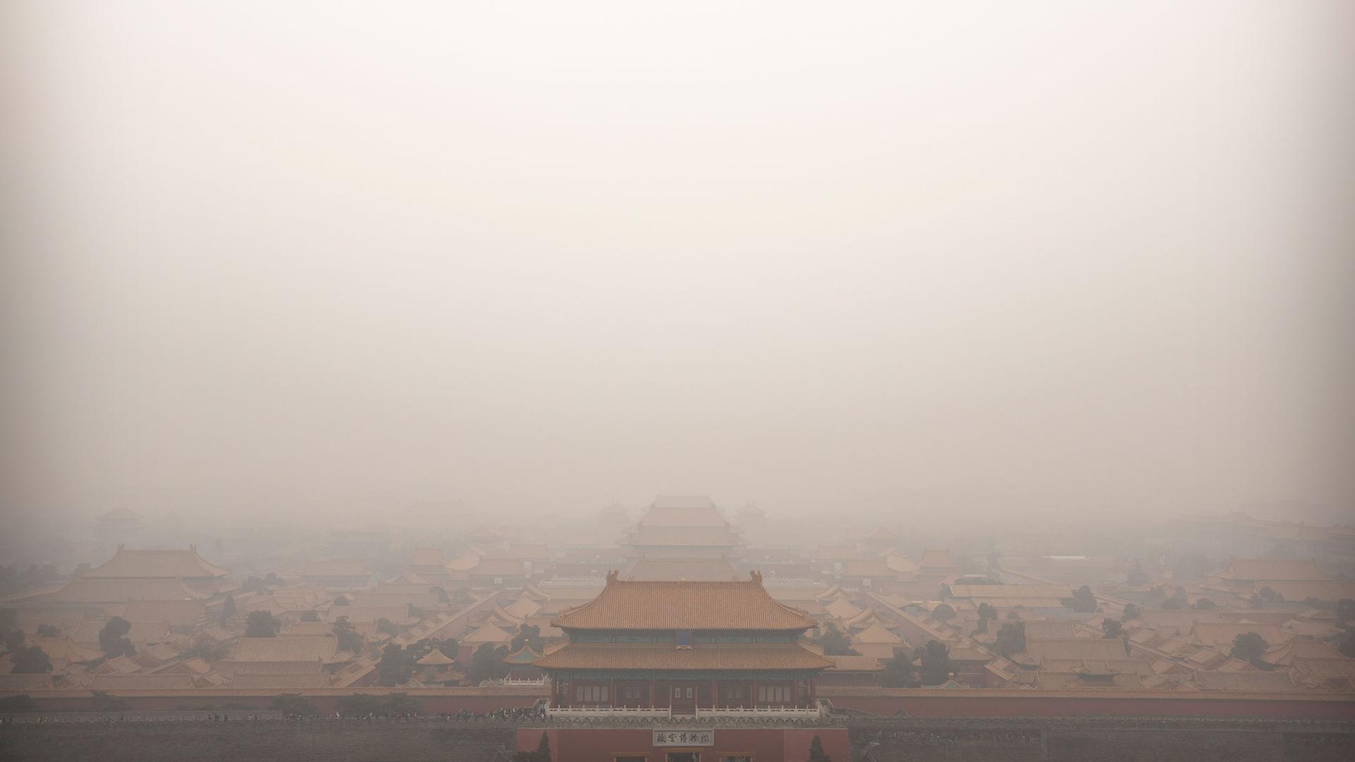 The top of a palace building in China's Forbidden City is barely viewable in a photograph showing a dense amount of smog.