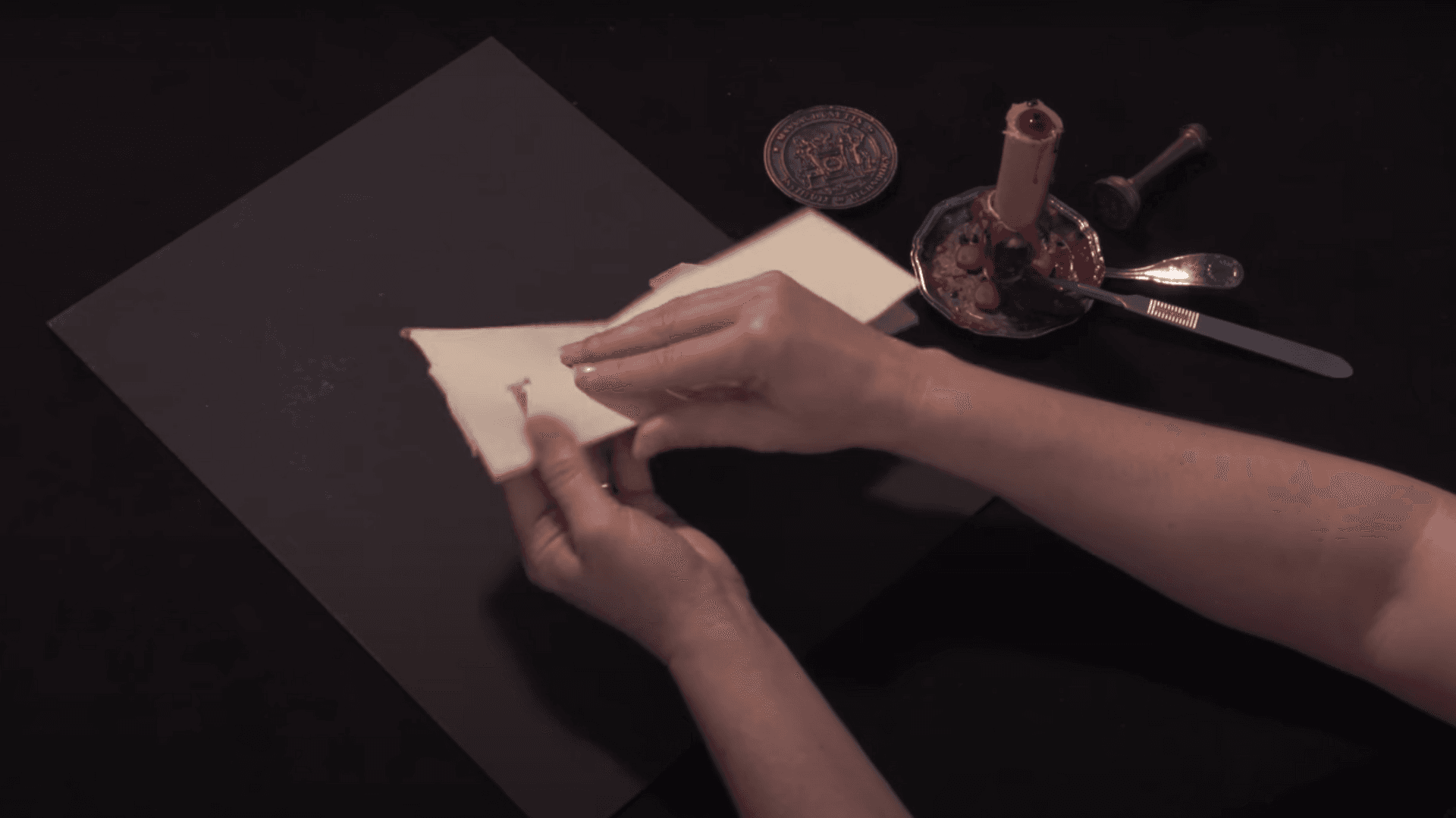 Hands fold a sheet of paper 