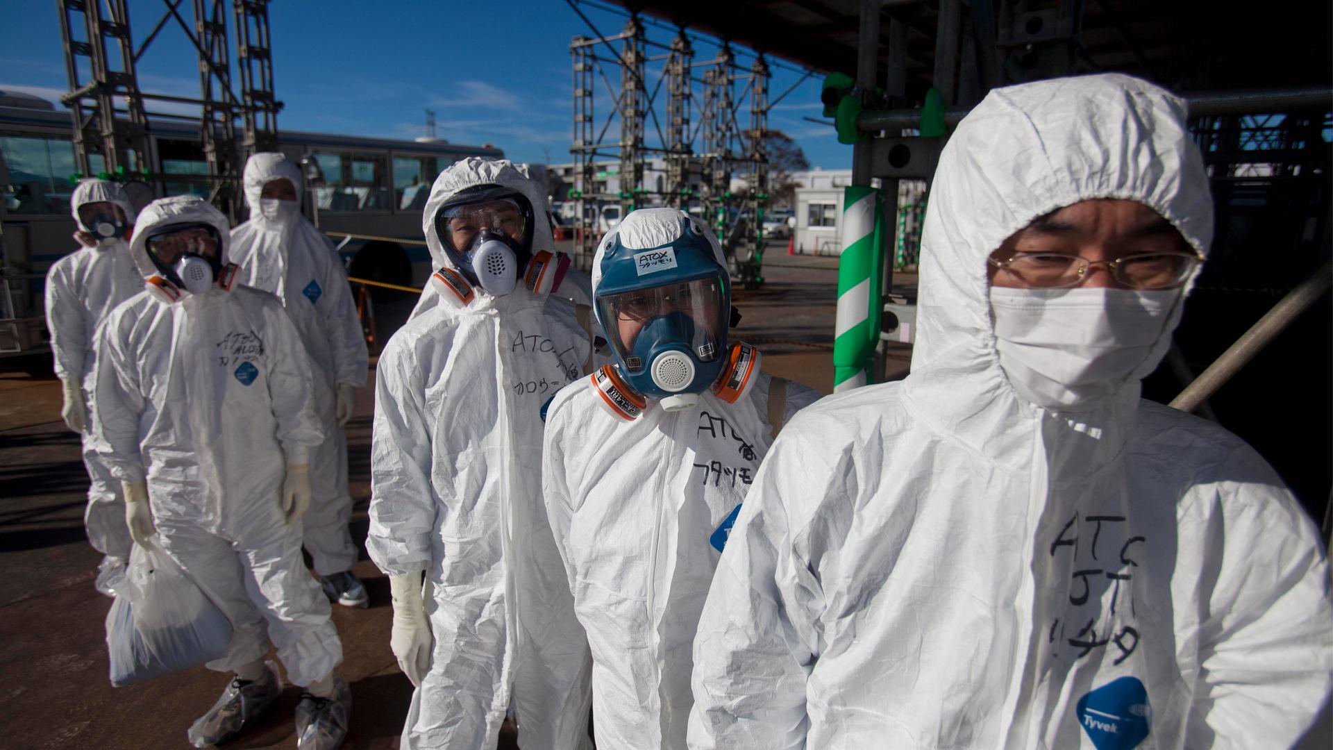 In this Nov. 12, 2011 file photo, workers in protective suits and masks wait to enter the emergency operation center at the crippled Fukushima Daiichi nuclear power station in Okuma, Japan.