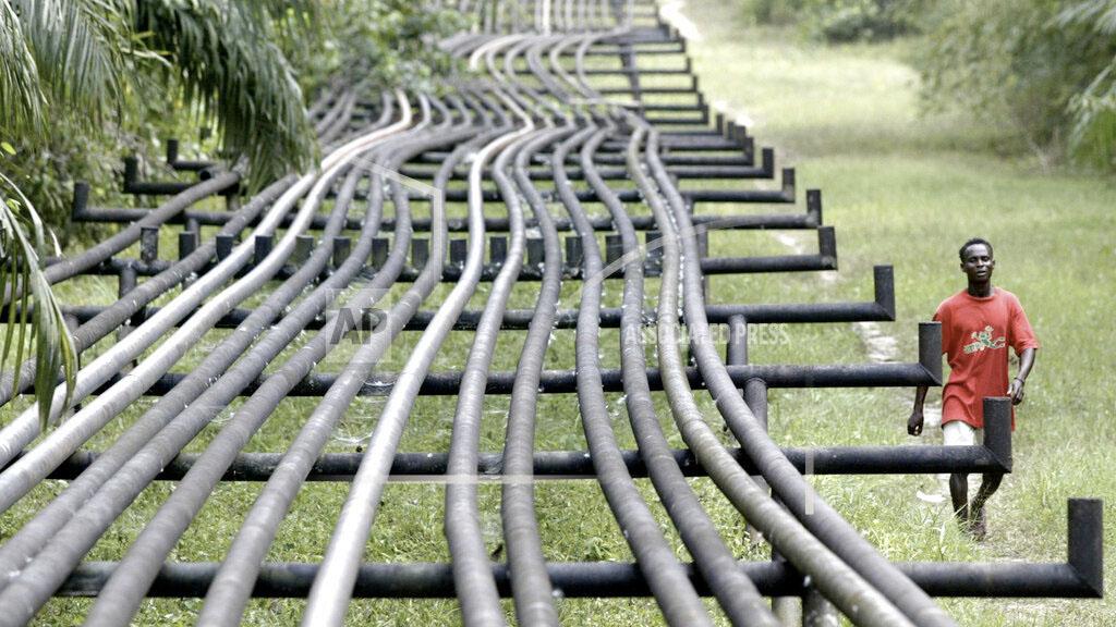 An unidentified man walks along oil pipelines belonging to Agip Oil company in Obrikom, Nigeria, Monday, March 6, 2006. 