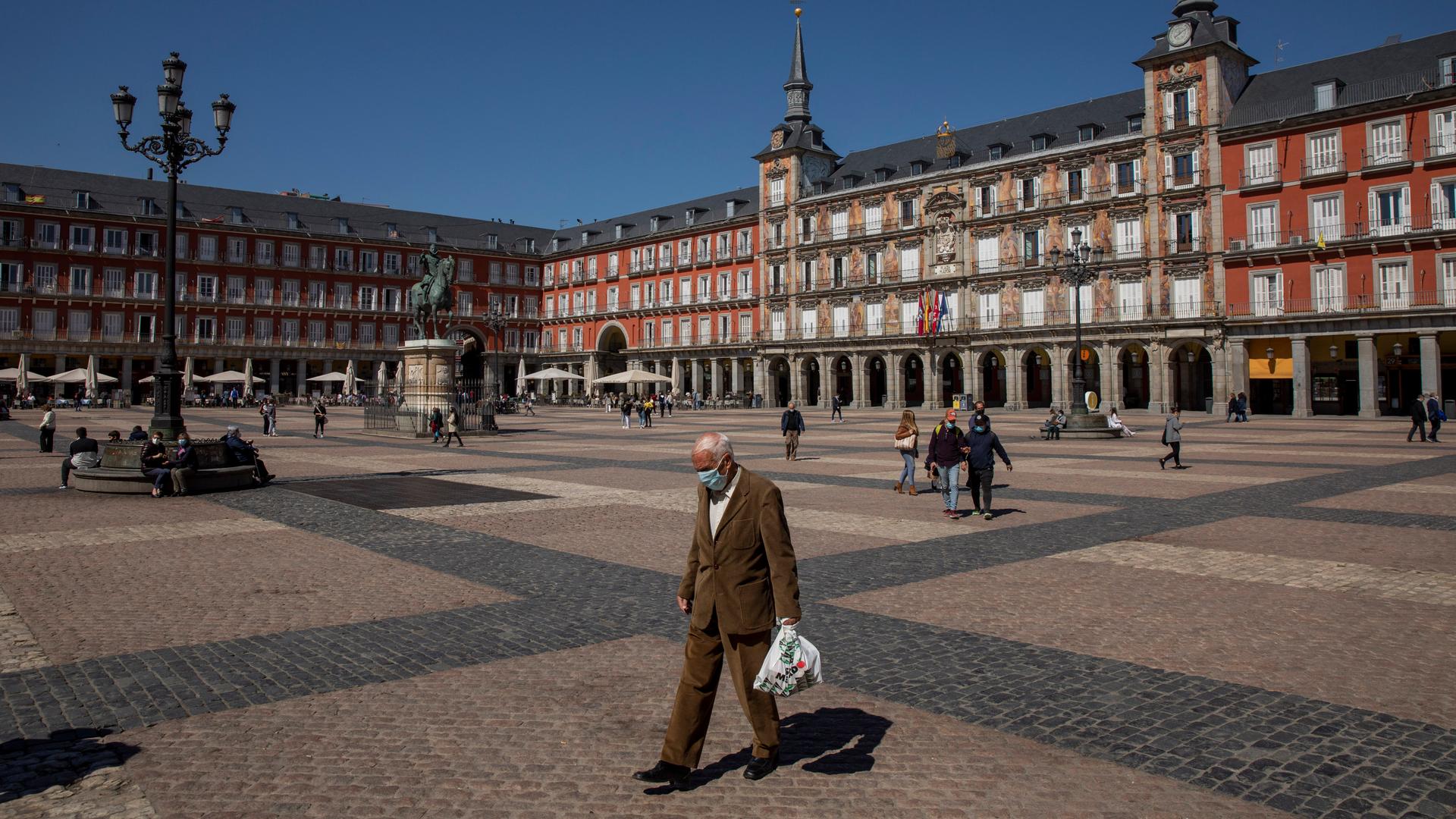 A man walks through a plaza during the day