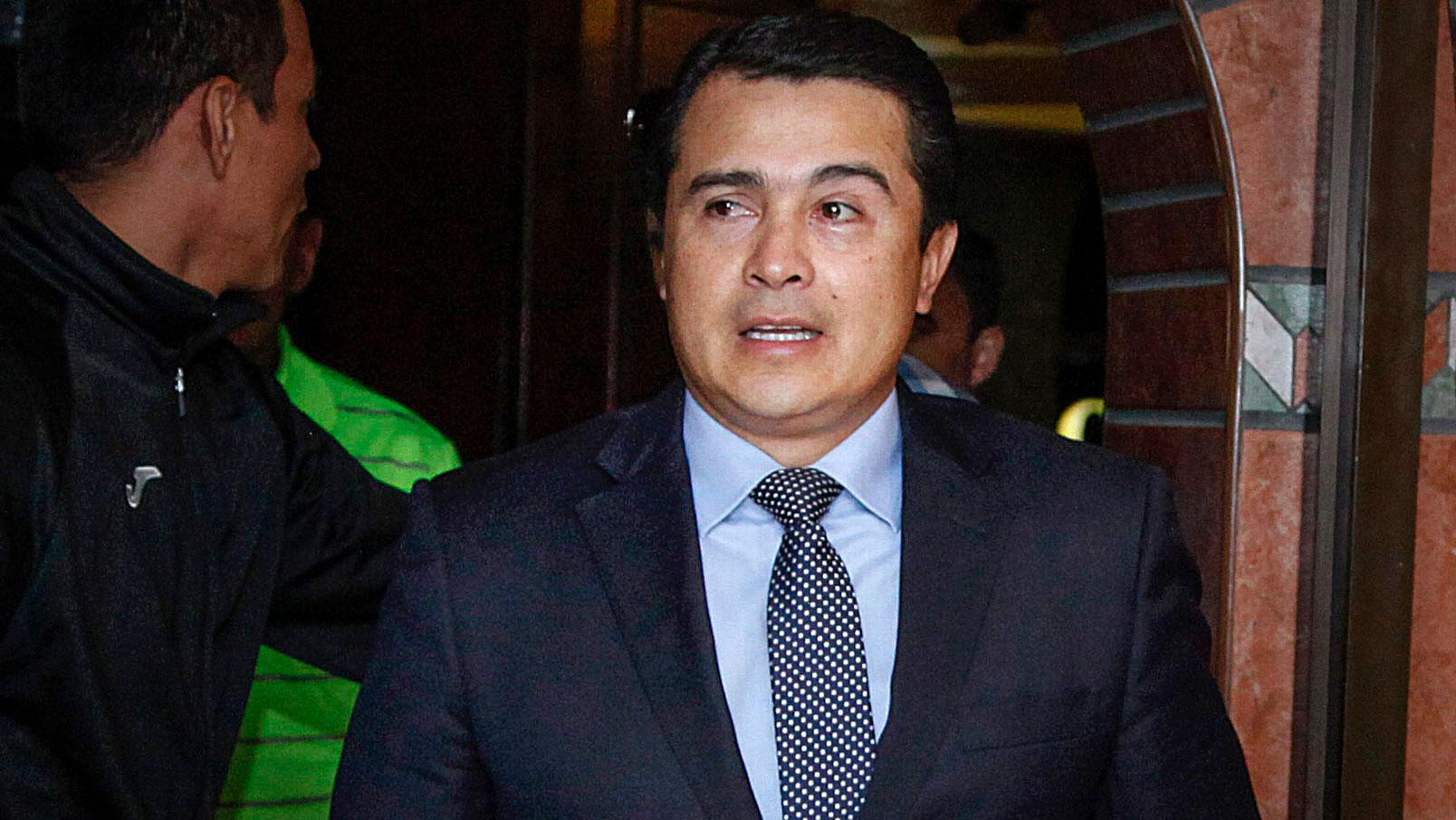 Juan Antonio "Tony" Hernández is shown wearing a blue suit and spotted tie.