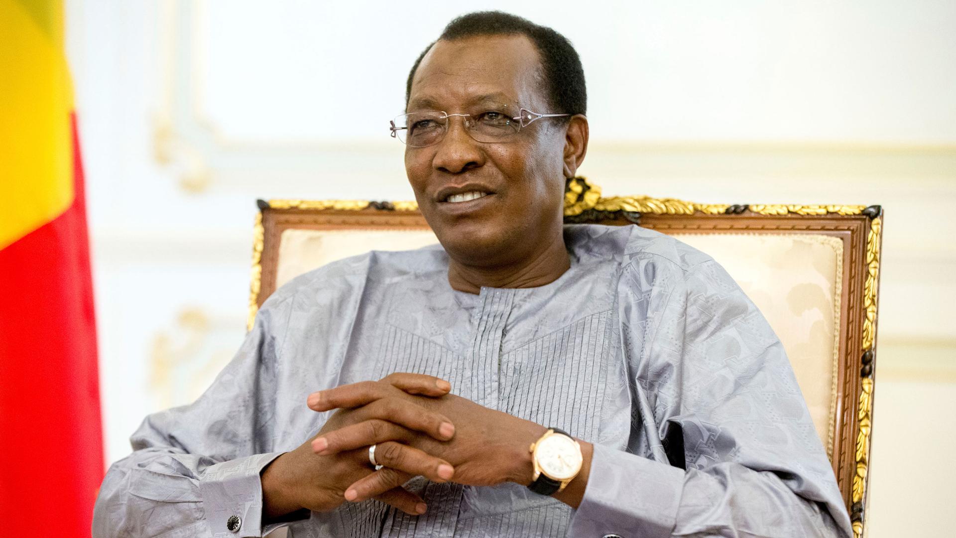 Chadian President Idriss Déby Itno is shown seated and with his hands folded.