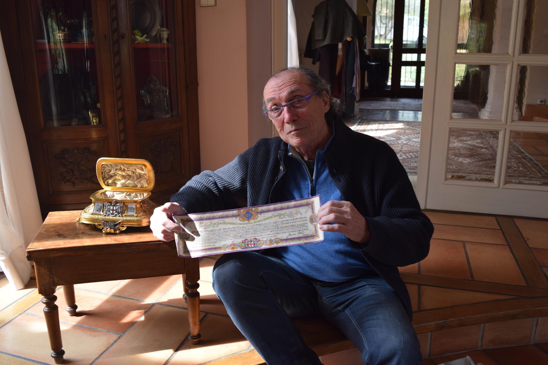 Michel Becker, art collector, sits with the golden chest featured in the 
