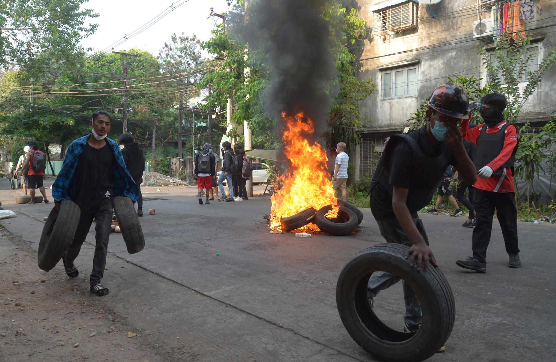 Anti-coup demonstrators gather tires to burn as they prepare to confront police during a protest in Tarmwe township, Yangon, Myanmar, April 1, 2021. 