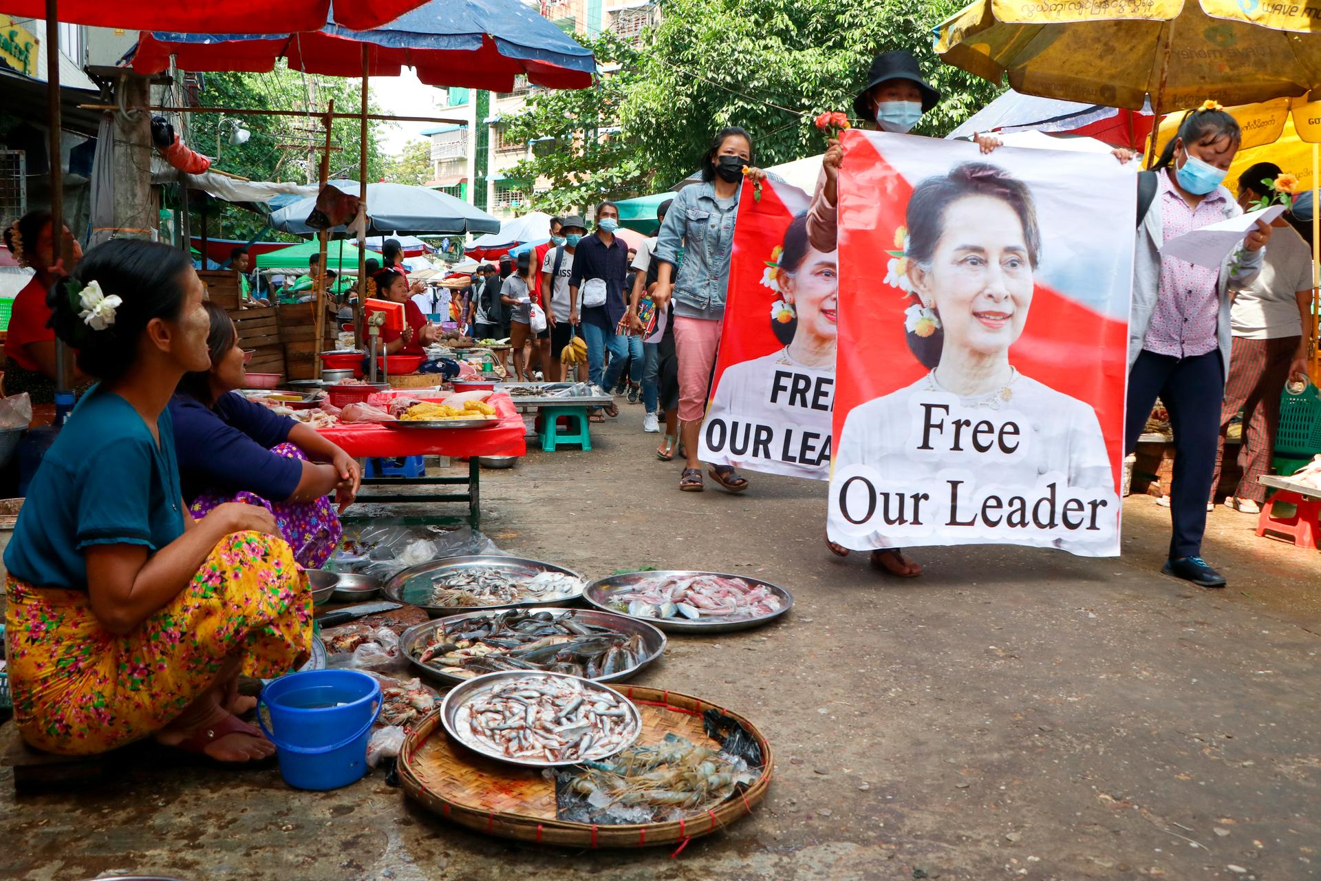 Anti-coup protesters walk through a market with images of ousted Myanmar leader Aung San Suu Kyi at Kamayut township in Yangon, Myanmar, April 8, 2021. They walked through the markets and streets of Kamayut township with slogans to show their disaffection