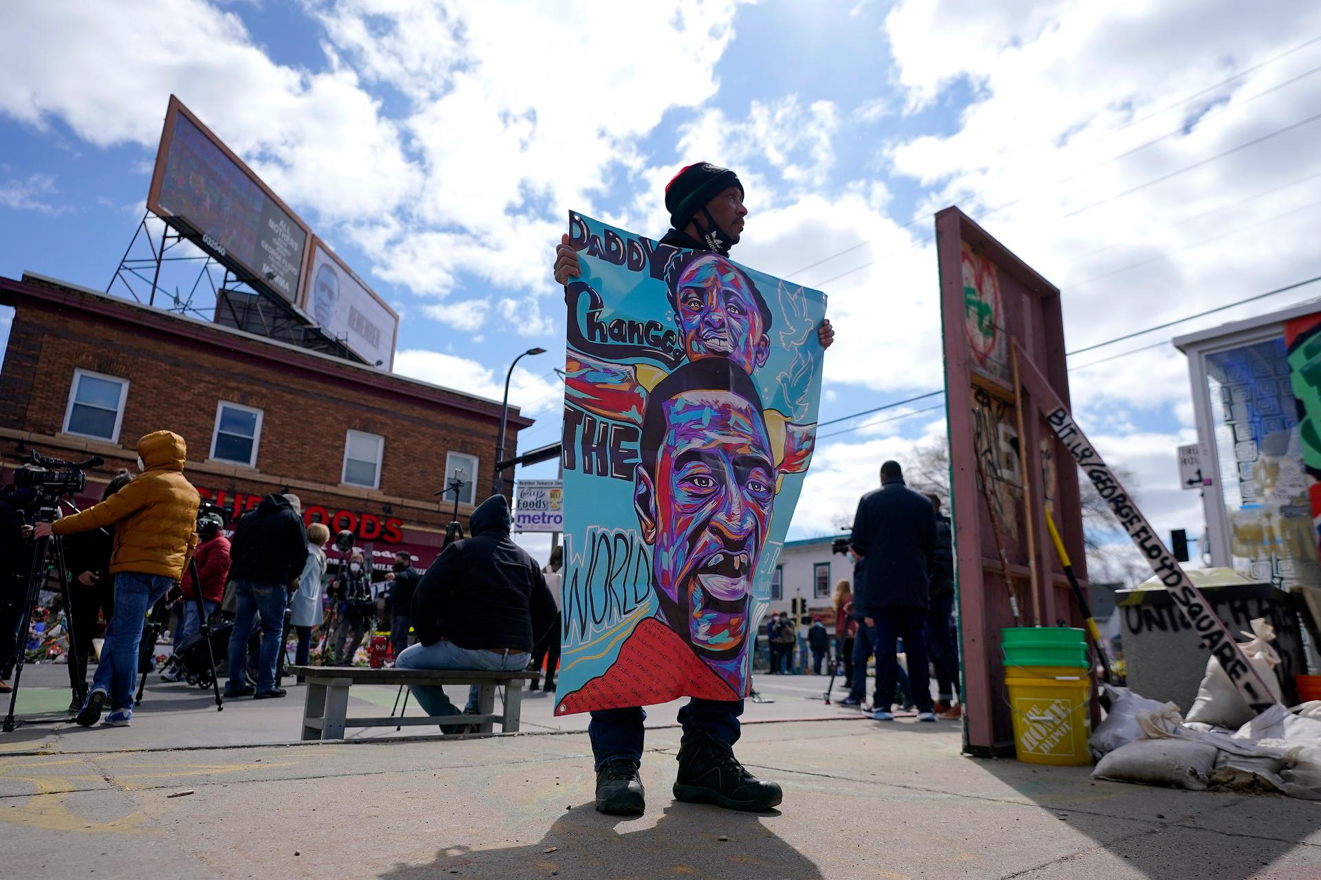 A man holds a sign at George Floyd Square, April 21, 2021, in Minneapolis, a day after former Minneapolis police Officer Derek Chauvin was convicted on all counts for the 2020 death of Floyd.