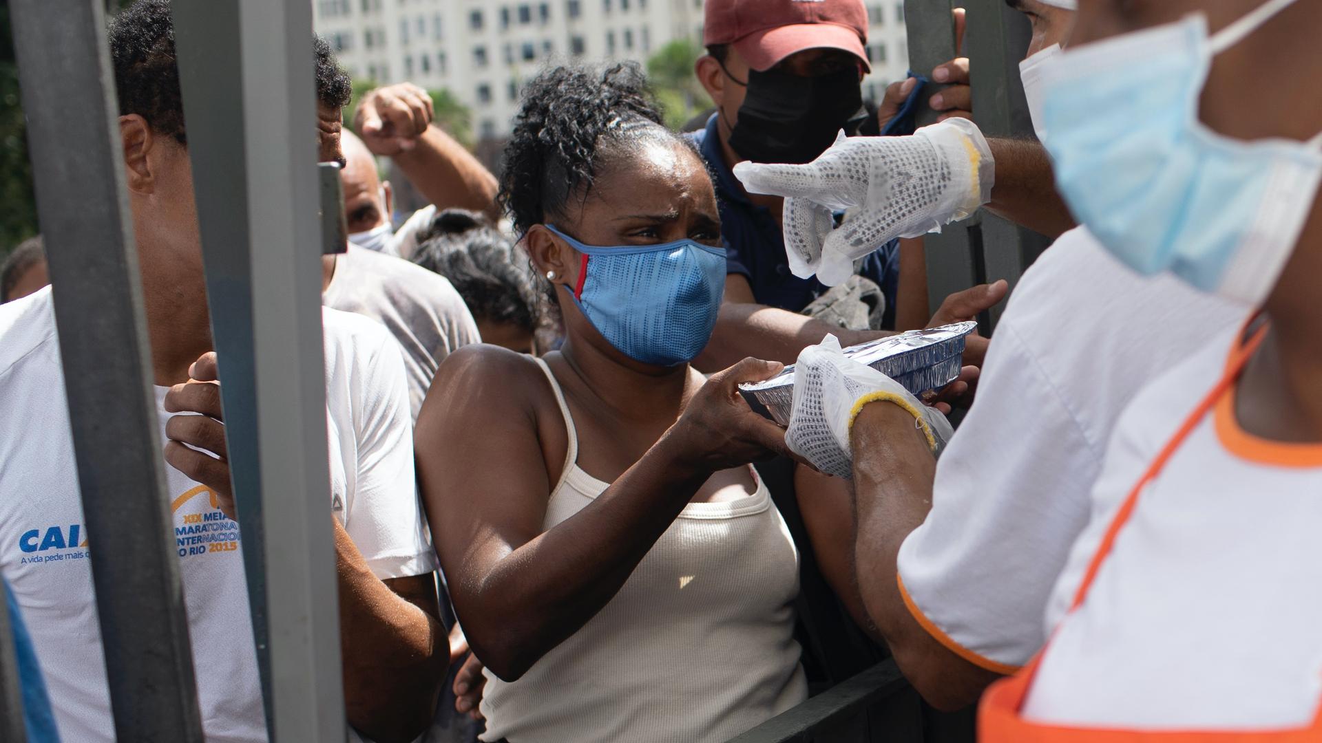 A woman receives a plate of food donated by the Leao Xlll Foundation amid the COVID-19 pandemic in Rio de Janeiro, Brazil, April 7, 2021.