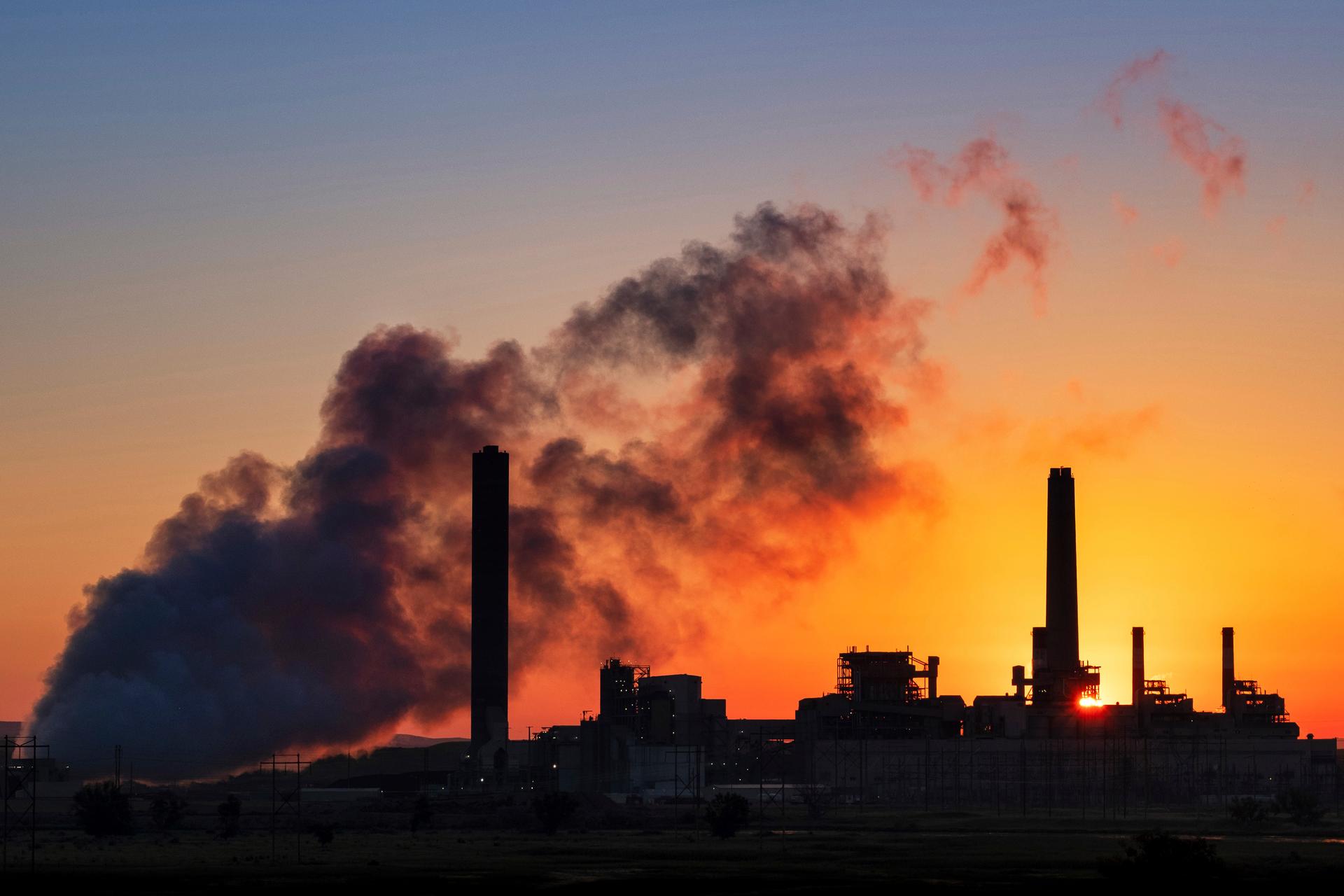 In this July 27, 2018, photo the Dave Johnson coal-fired power plant is silhouetted against the morning sun. 