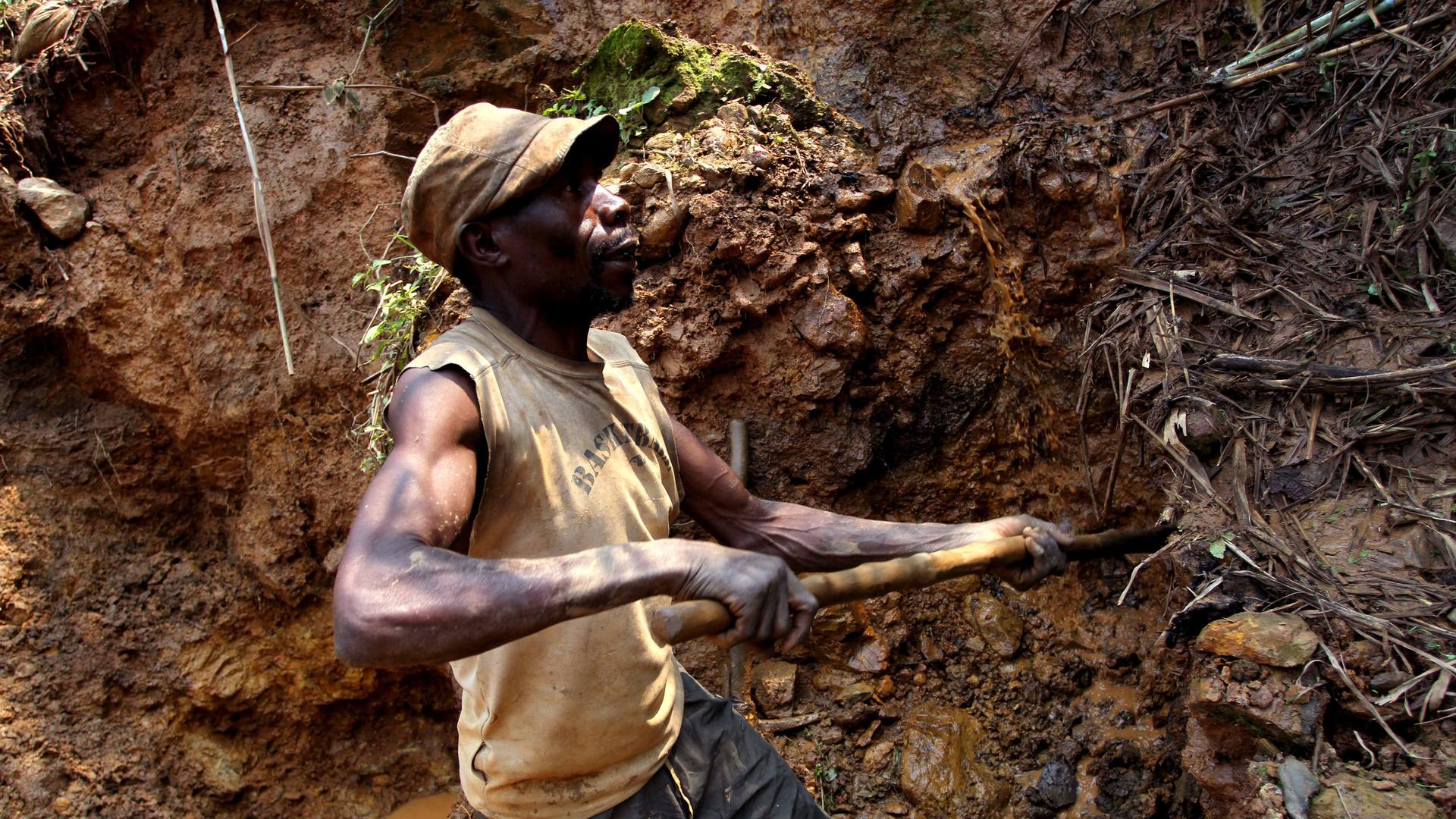 In this photo taken Aug. 17, 2012, one of the few remaining miners digs out soil which will later be filtered for traces of cassiterite, the major ore of tin, at Nyabibwe mine, in eastern Congo. 