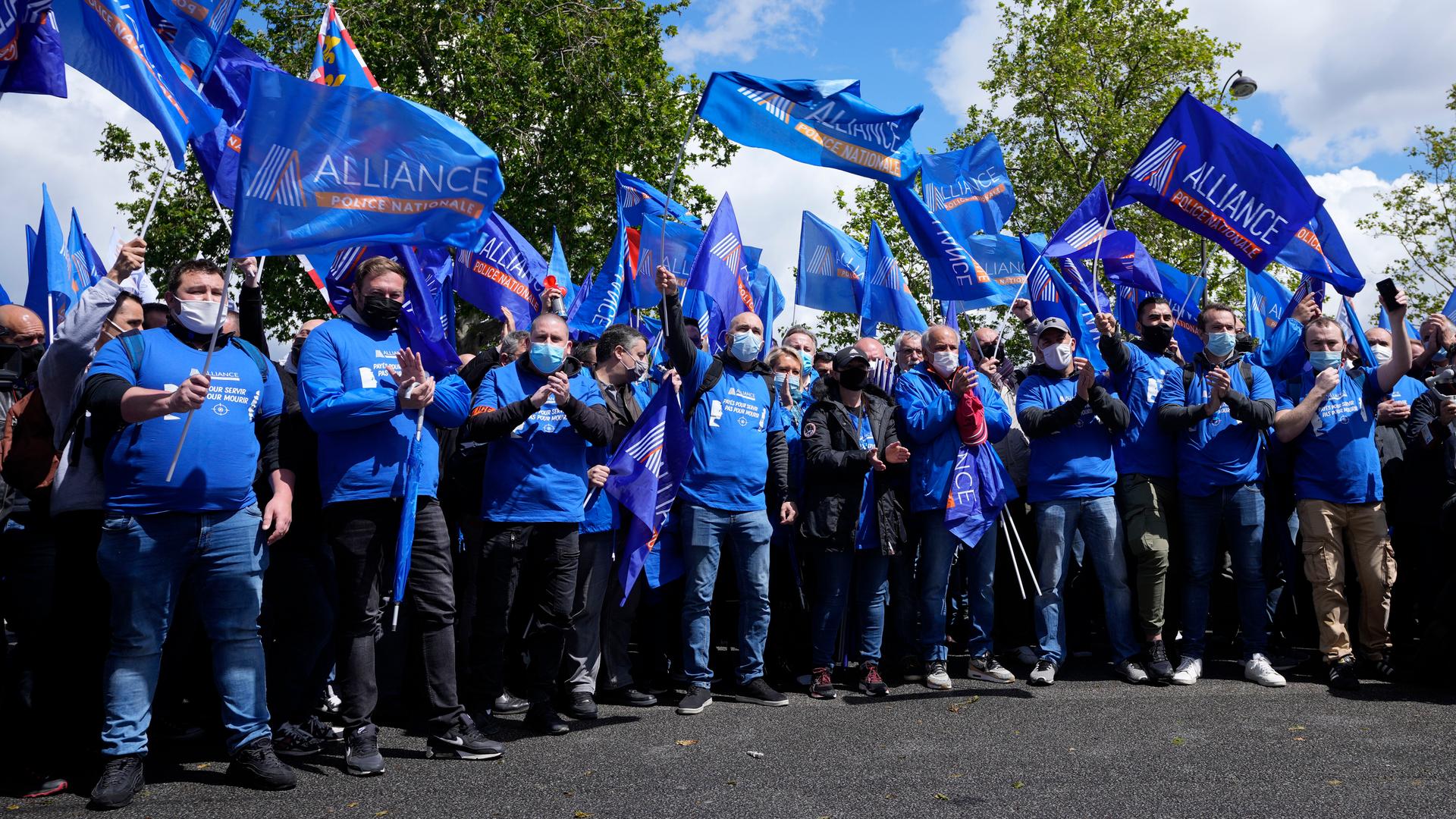 French police officers wearing blue shirts and waving blue flags demonstrate Wednesday, May 19, 2021 in Paris. French police, feeling angry, vulnerable to attacks and useless