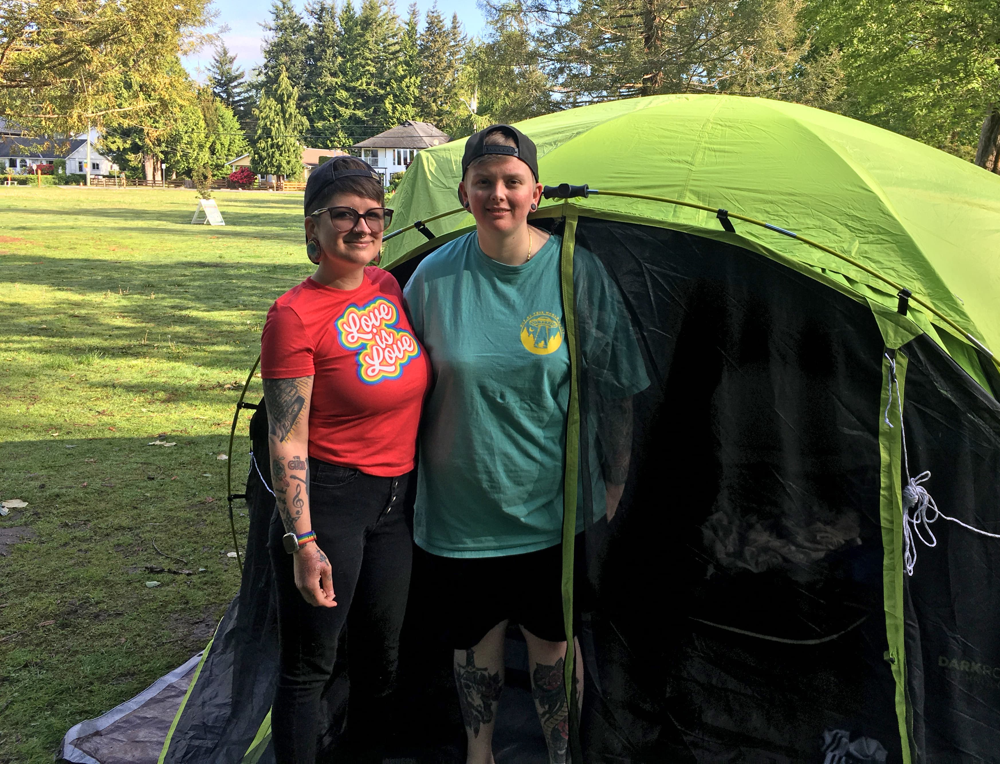 Alexis Gurr (left), of Everett, Washington, and her wife, Katrina Gurr, of Port Moody, British Columbia, pose outside their tent on the US side of Peace Arch Park.