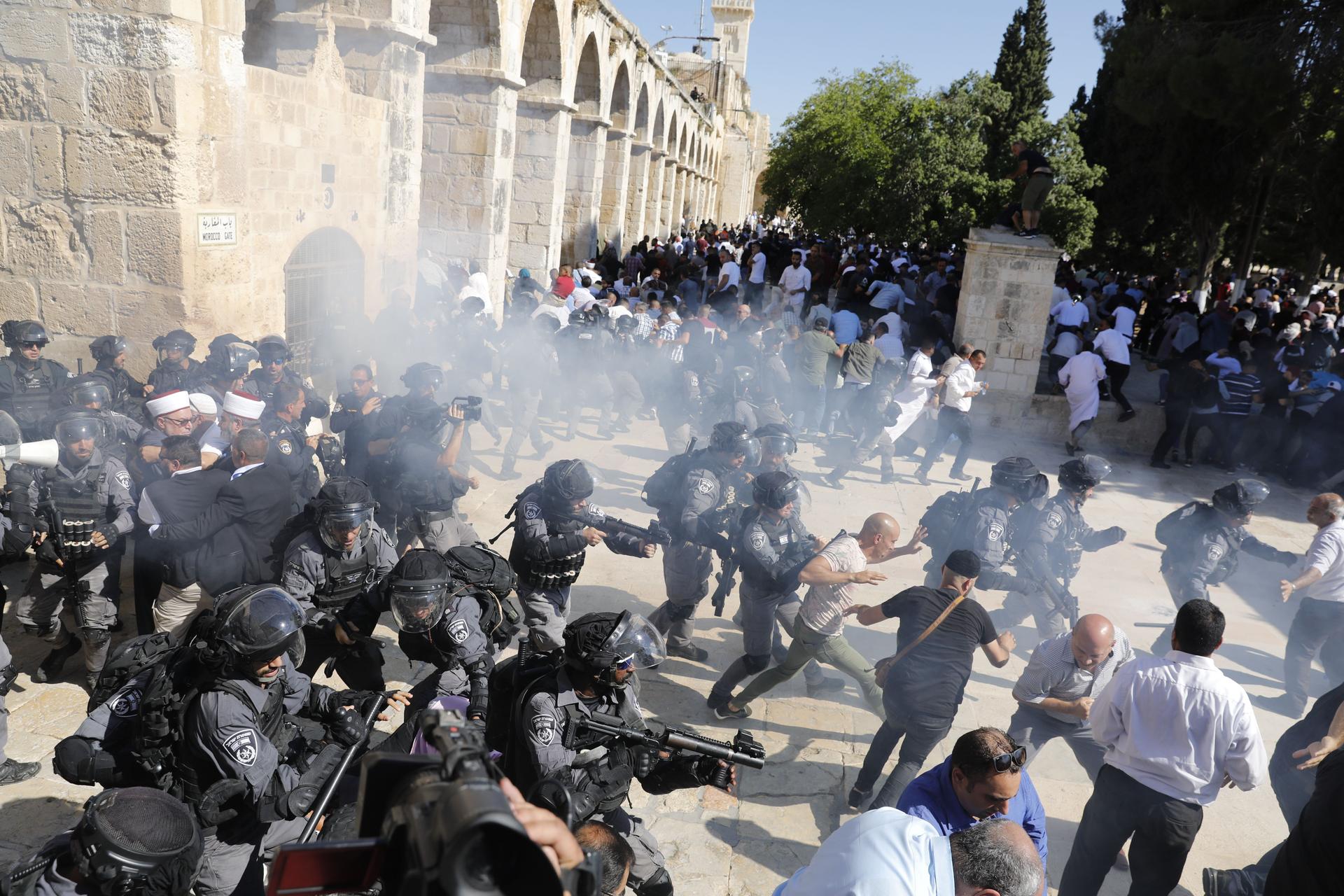 Israeli security forces firing grenades at a crowd of protesters