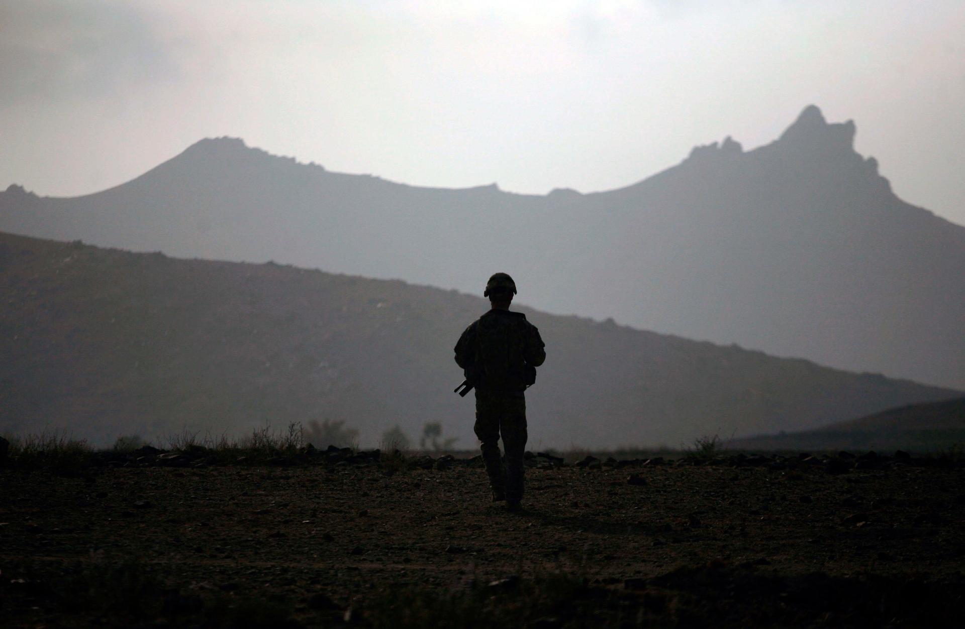 Silhouette of soldier with mountains in the background