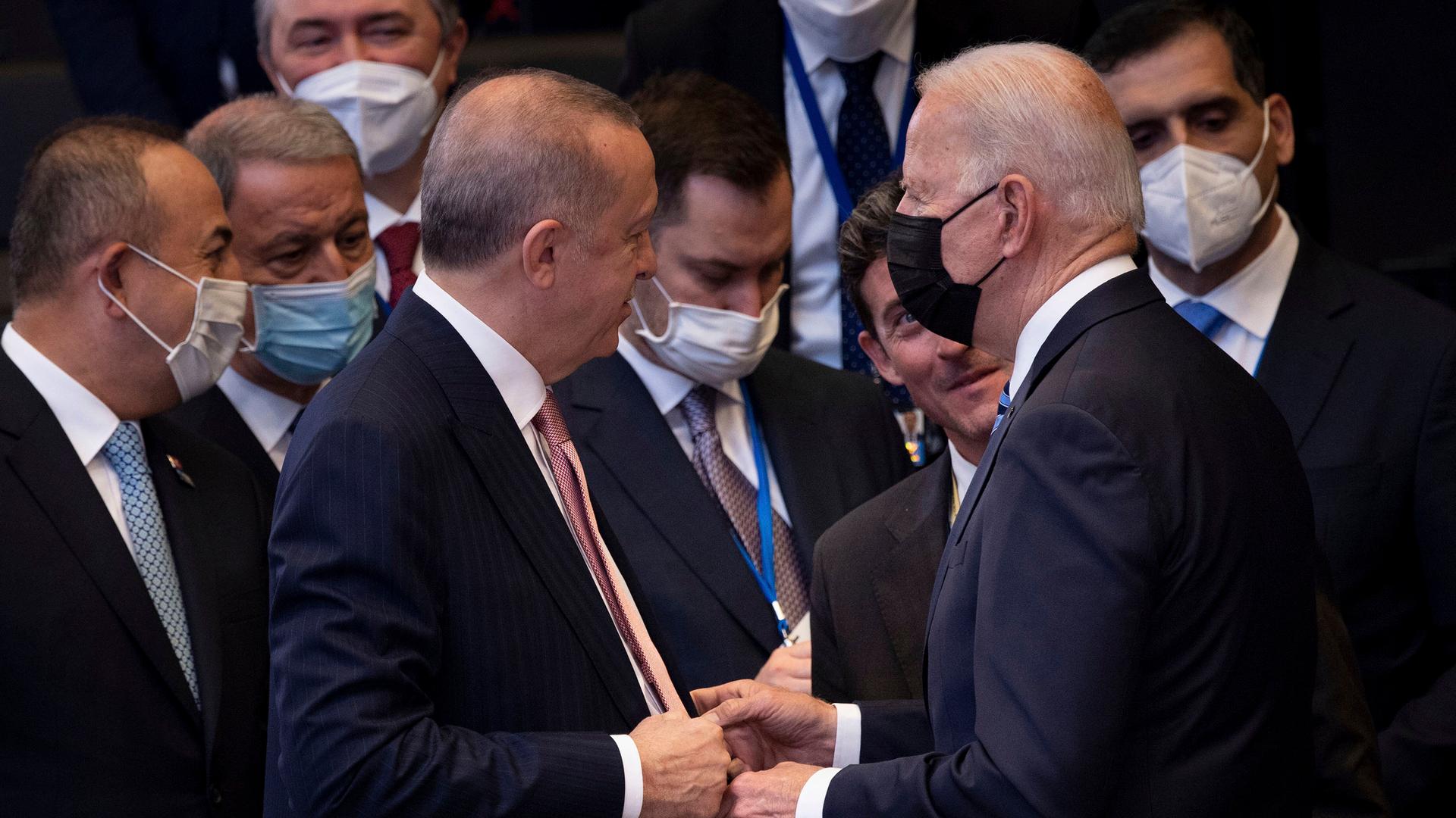 Turkey's President Recep Tayyip Erdoğan, center left, greets US President Joe Biden, center right, during a plenary session during a NATO summit at NATO headquarters in Brussels, Monday, June 14, 2021.
