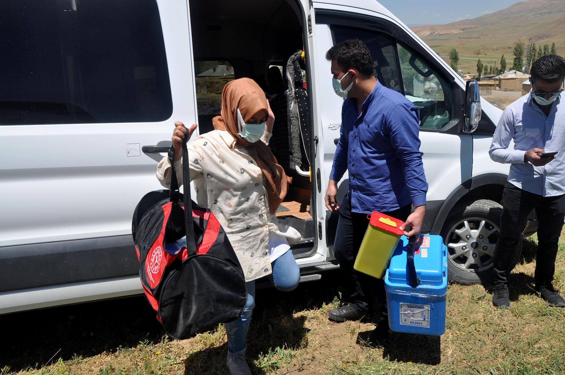 Health workers unload equipment to give out COVID vaccines in Ömerova, a village in Turkey’s eastern Kurdish region.