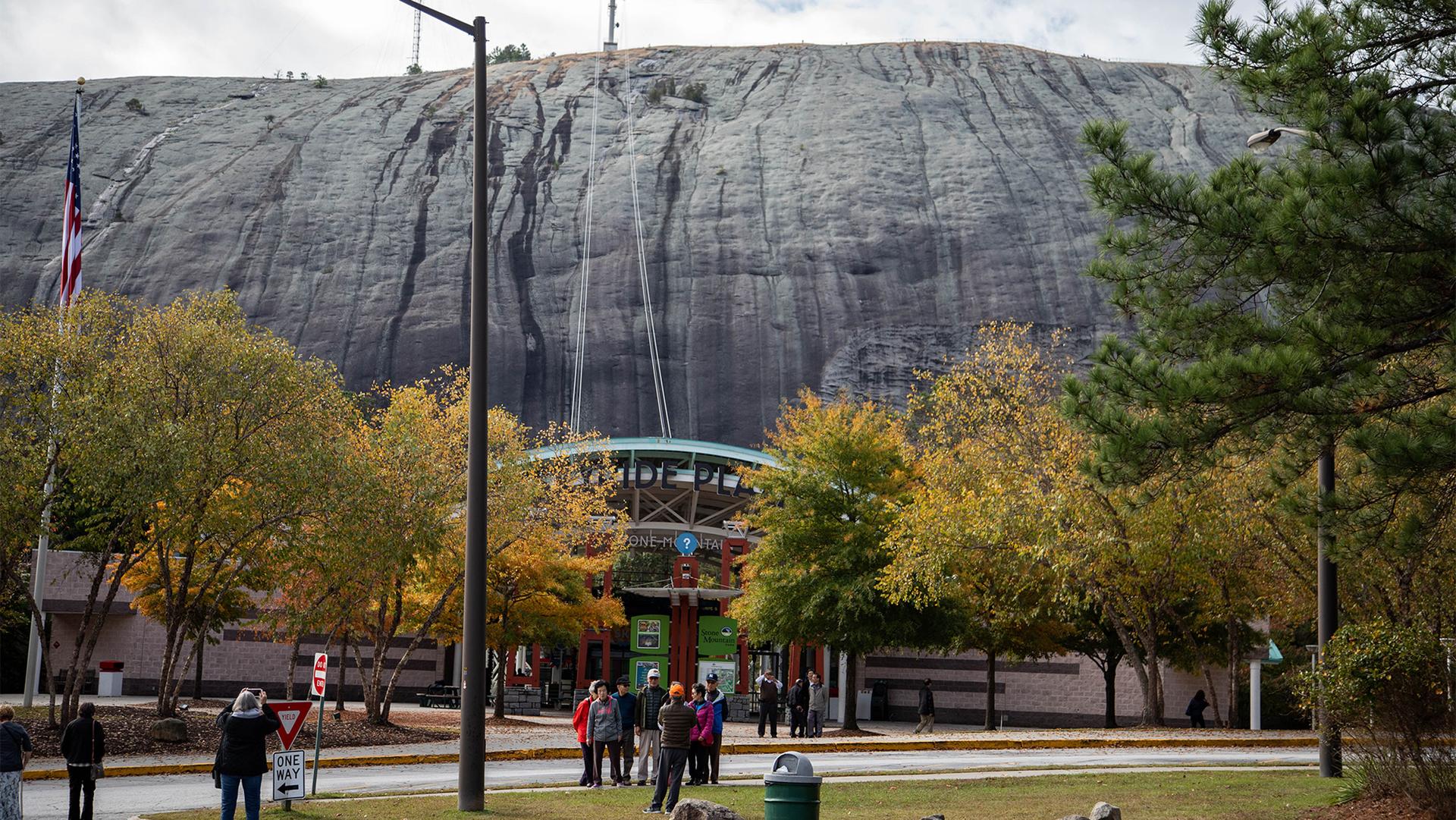 Tourists at the mingling with Stone Mountain and colorful trees in the background