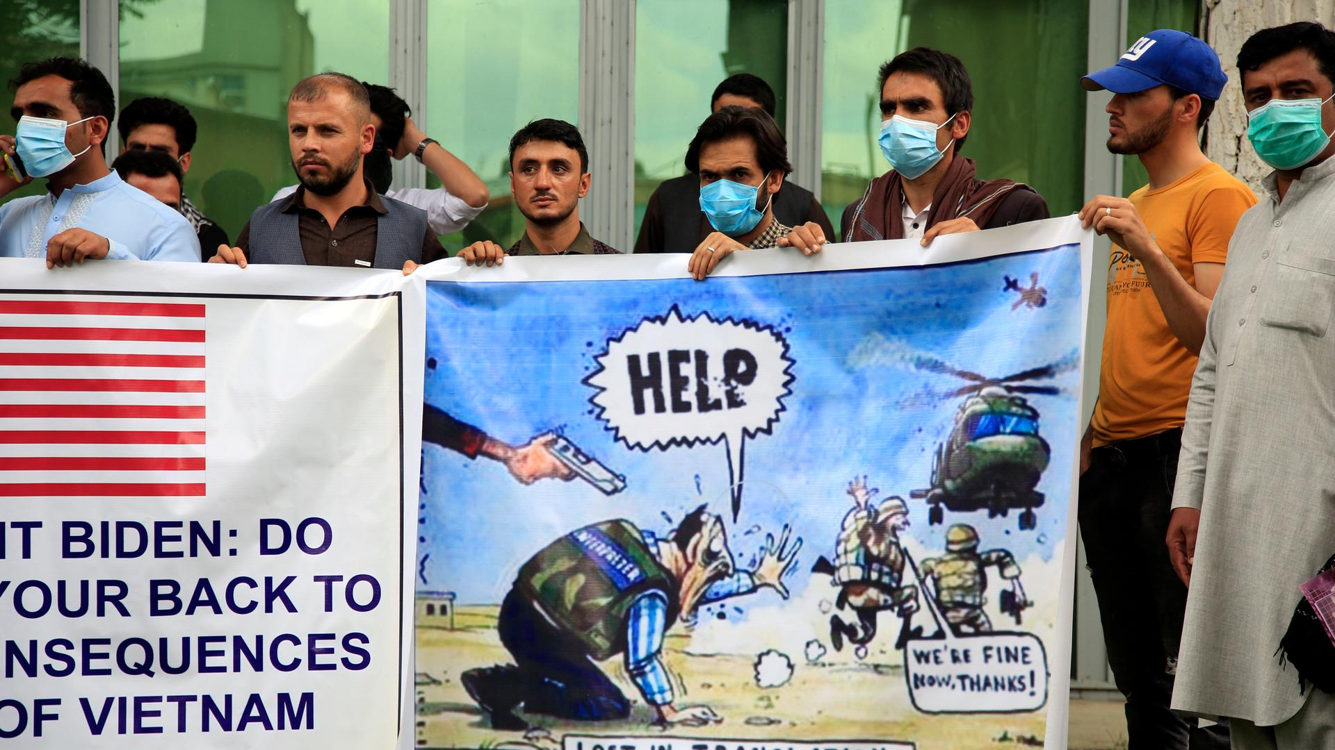 In this Friday, April 30, 2021, file photo former Afghan interpreters hold banners during a protest against the US government and NATO in Kabul, Afghanistan. 