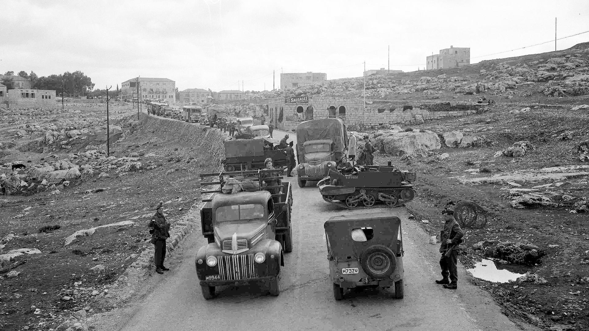 A line of vehicles, stretching for almost a mile, waits to pass through a road block on the main road from Jerusalem to Tel Aviv, Feb. 6, 1947. The road block is manned by members of the Royal Irish Fusiliers. 