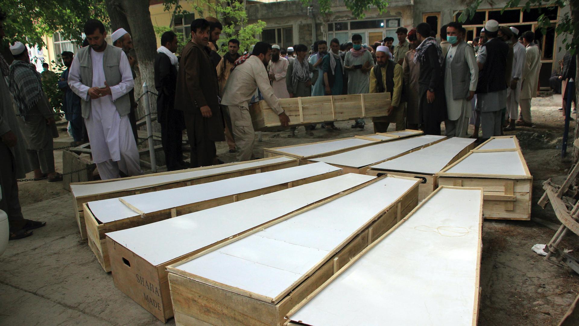 The coffins of the victims in Tuesday's attack are placed on the ground at a hospital in northern Baghlan province, Afghanistan, June 9, 2021. 