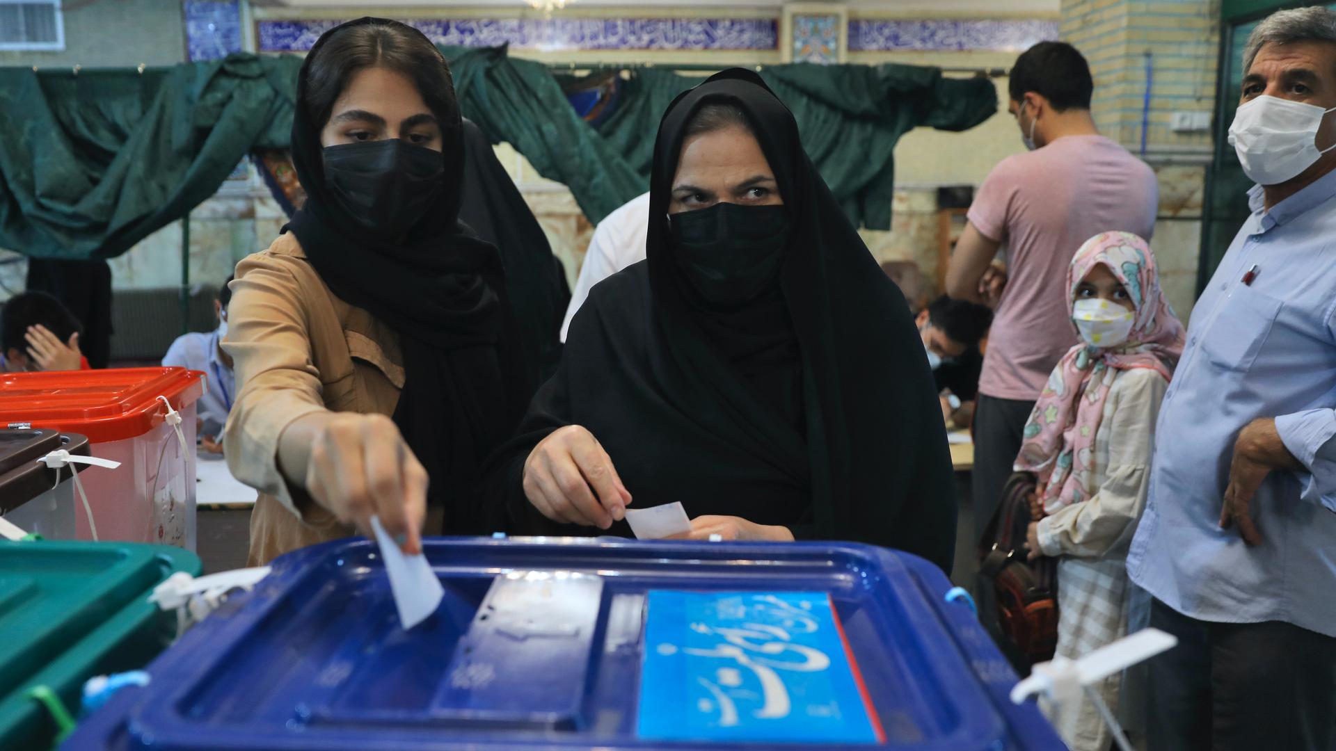 Voters cast their ballots for the presidential elections at a polling station in Tehran, Iran, June 18, 2021. 