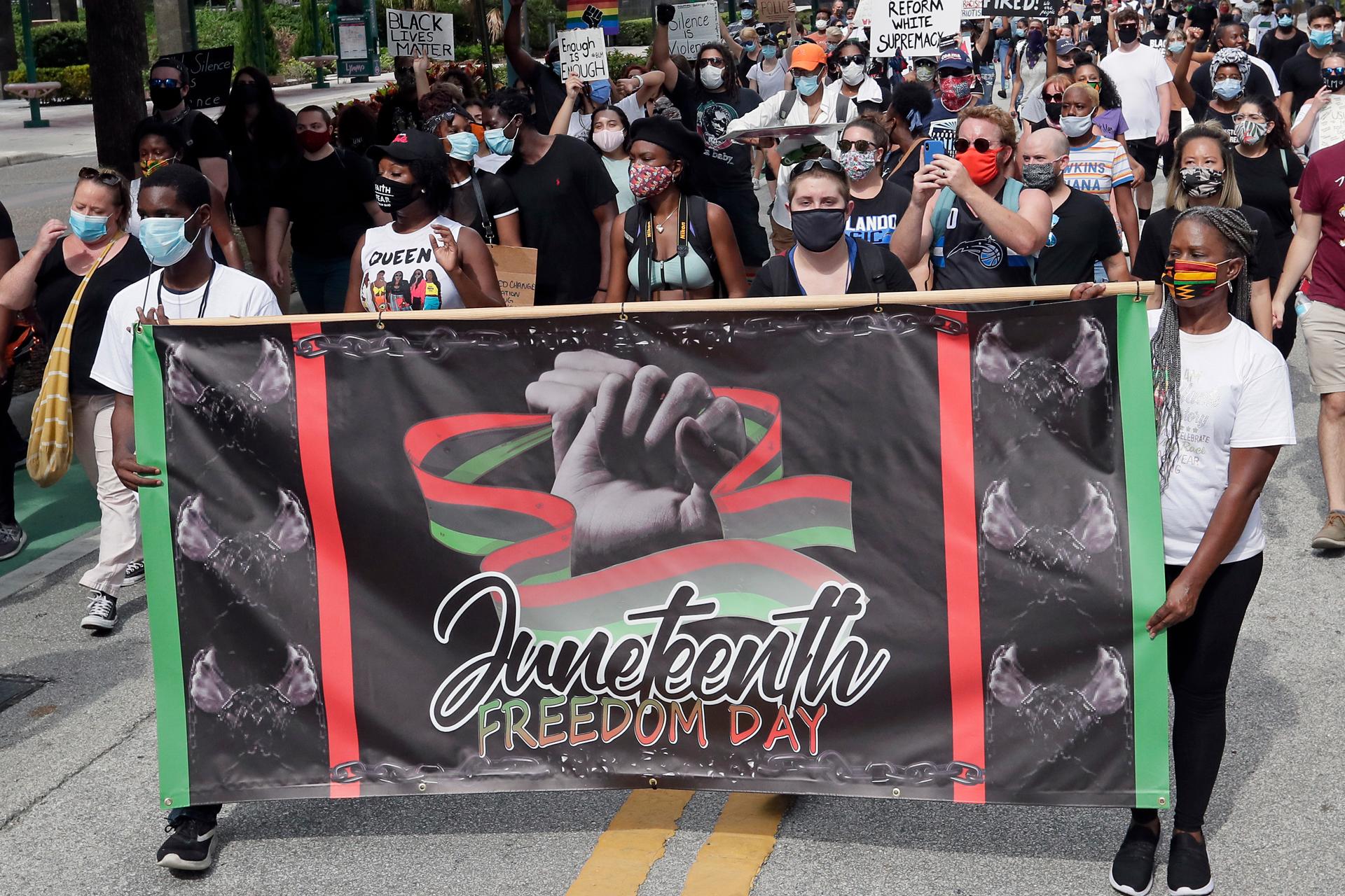 Demonstrators march through downtown Orlando, Florida, during a Juneteenth event, June 19, 2020.