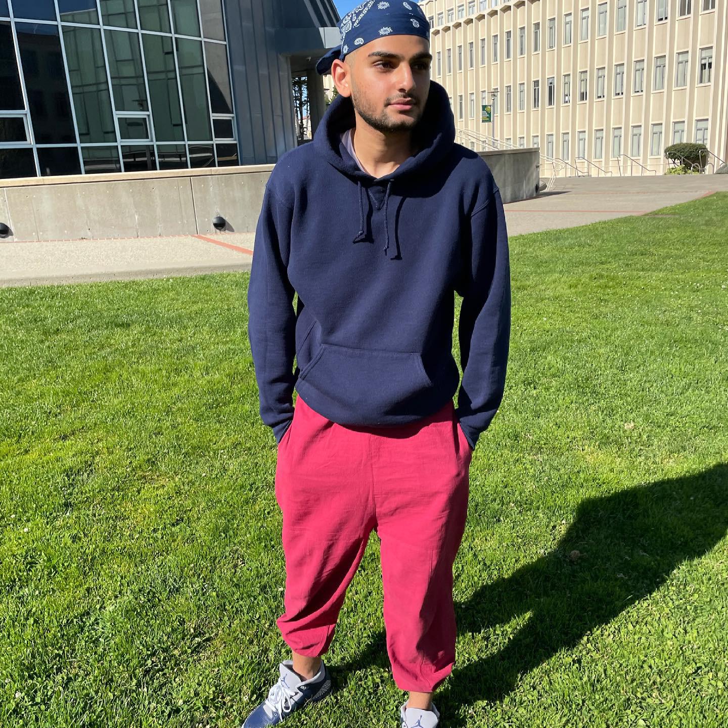Abdullah Jamalallail wears pink sweats and a blue hoodie as a college student in San Francisco.