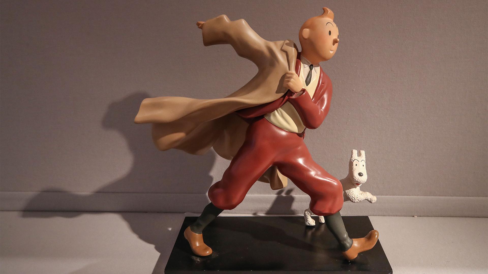 A 1988 polychrome resin sculpture is displayed of the comic character Tintin and his dog snowy