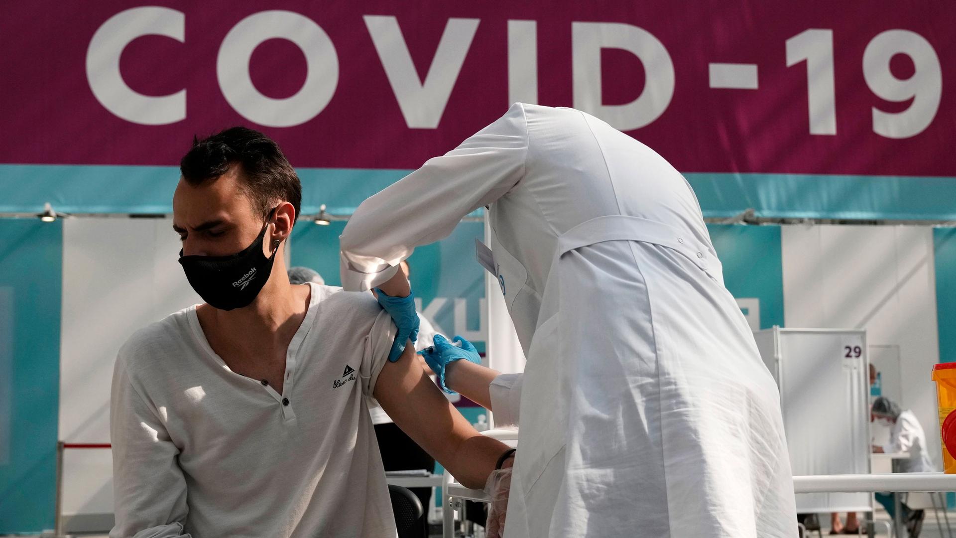 A medical worker administers a shot of Russia's Sputnik V coronavirus vaccine at a vaccination center in Gostinny Dvor, a huge exhibition place in Moscow, Russia. 