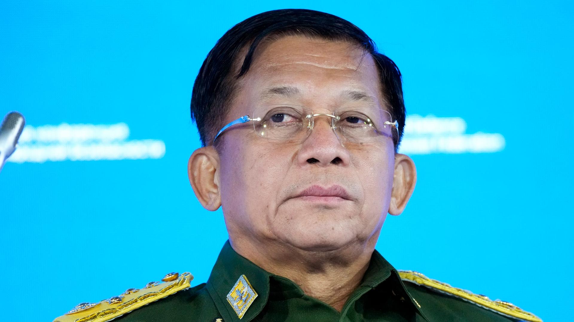 Senior General Min Aung Hlaing is shown wearing glasses and a green military uniform with gold epaulettes.