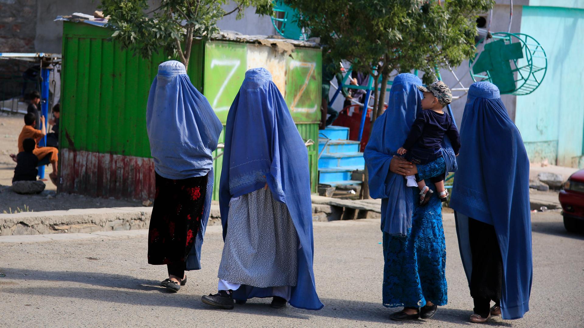 Afghan women walk on the road in Kabul, Afghanistan, Thursday, May 13, 2021.