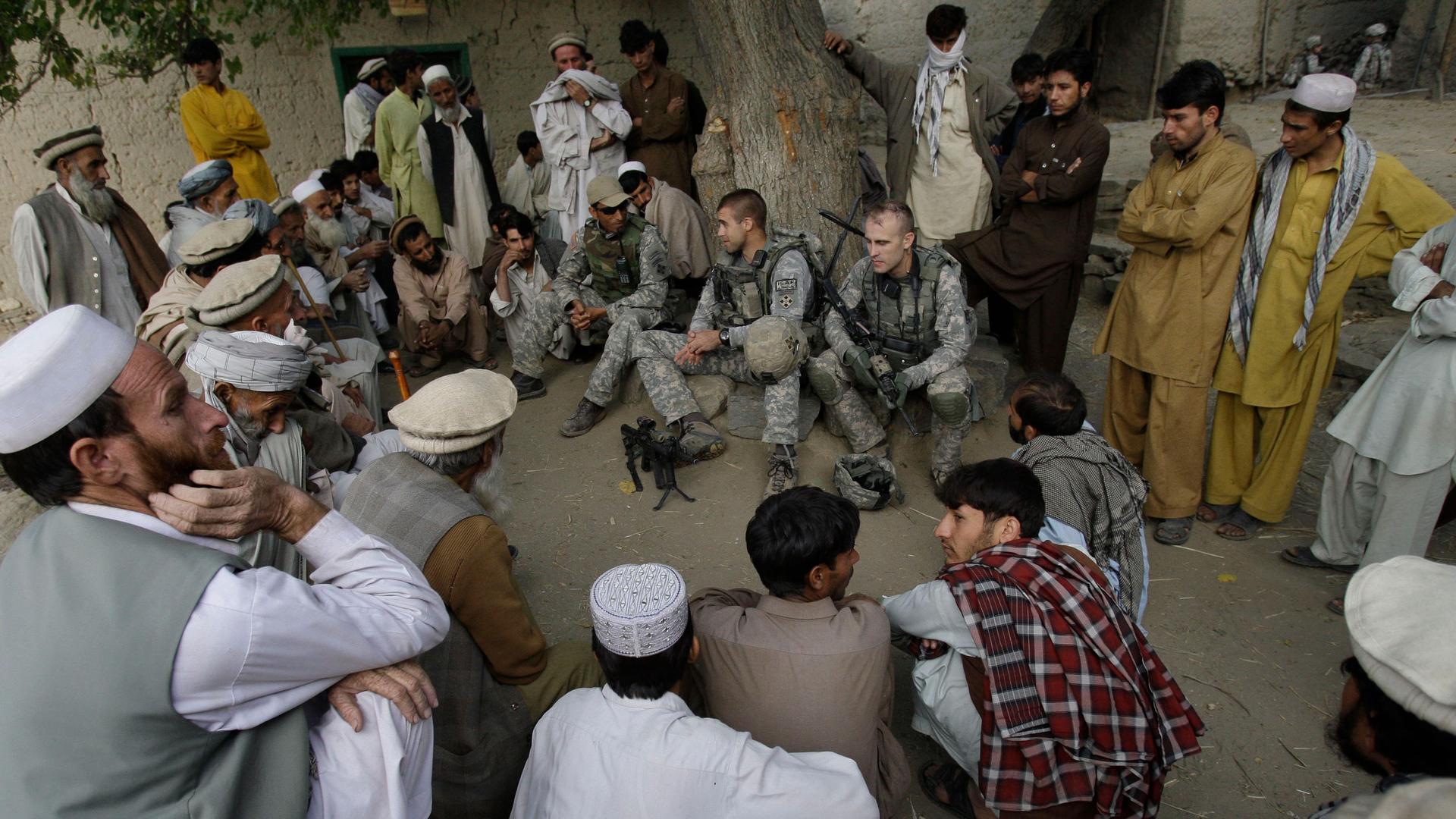 Lt. Thomas Goodman meets with villagers in Qatar Kala in the Pech Valley of Afghanistan's Kunar province with his interpreter Ayazudin Hilal.