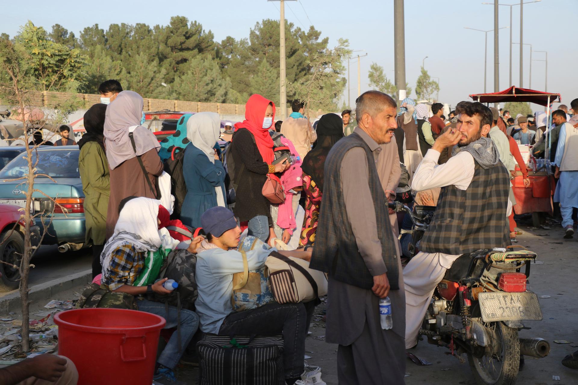 Hundreds of people gather near an evacuation control checkpoint during ongoing evacuations at Hamid Karzai International Airport, in Kabul.